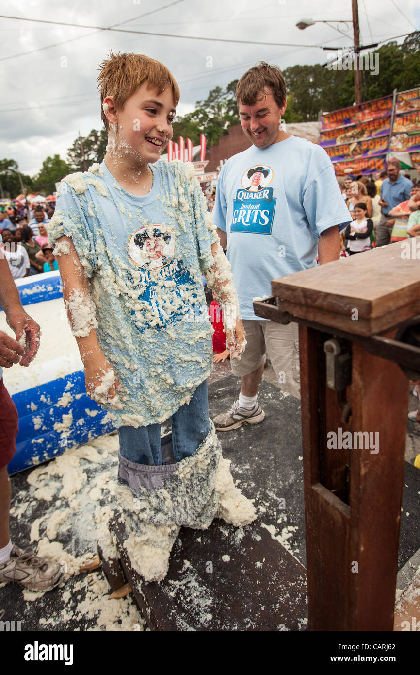 A competitor smiles as he is weighed after rolling in a pool of instant