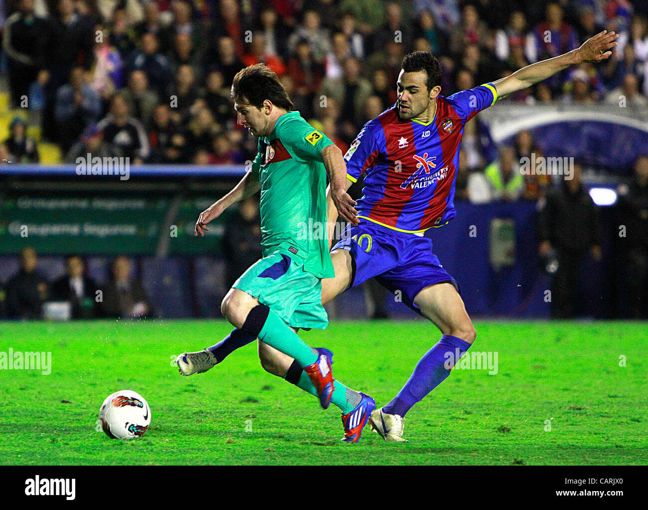 Liga BBVA - Soccer, Spain- Levante UD vs. FC Barcelona - Matchday   - 14/04/2012 - Messi dribbles Iborra Stock Photo