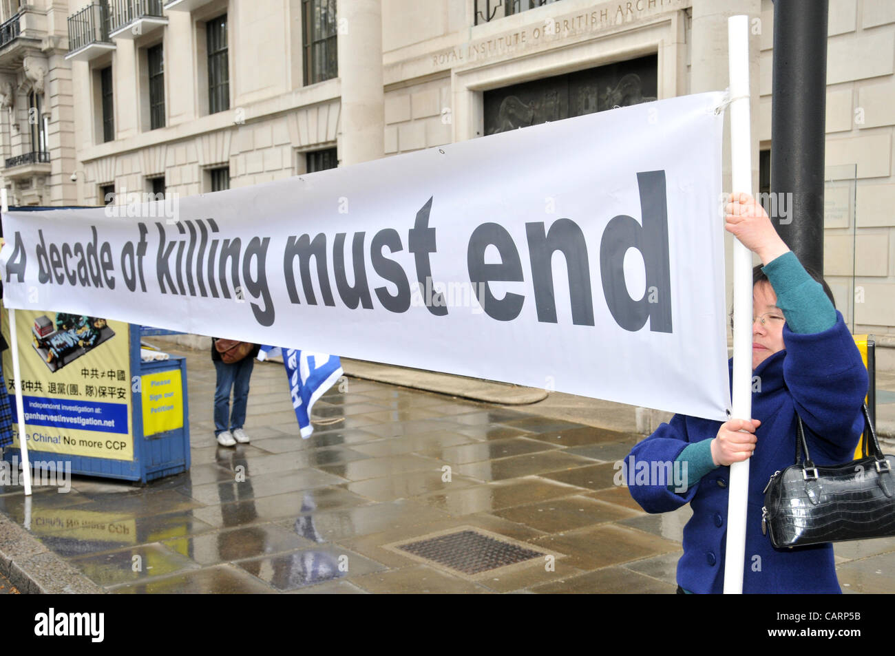 Falun Dafa protesters hold banners opposite the Chinese Embassy in London. A spiritual discipline in China from 1992, the practice is now banned in China and members claim human rights abuses by the Chinese government. Sunday 15th April 2012 Stock Photo