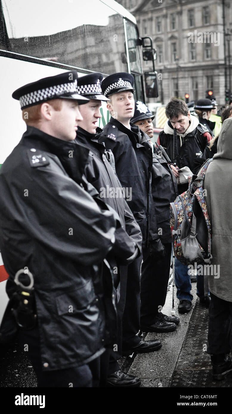 18/04/12, London, UK: Line of police officers stand watch as wheelchair-users block the road at Trafalgar Square. The protest was intended to highlight issues faced by disabled people and changes to disability benefits. Stock Photo