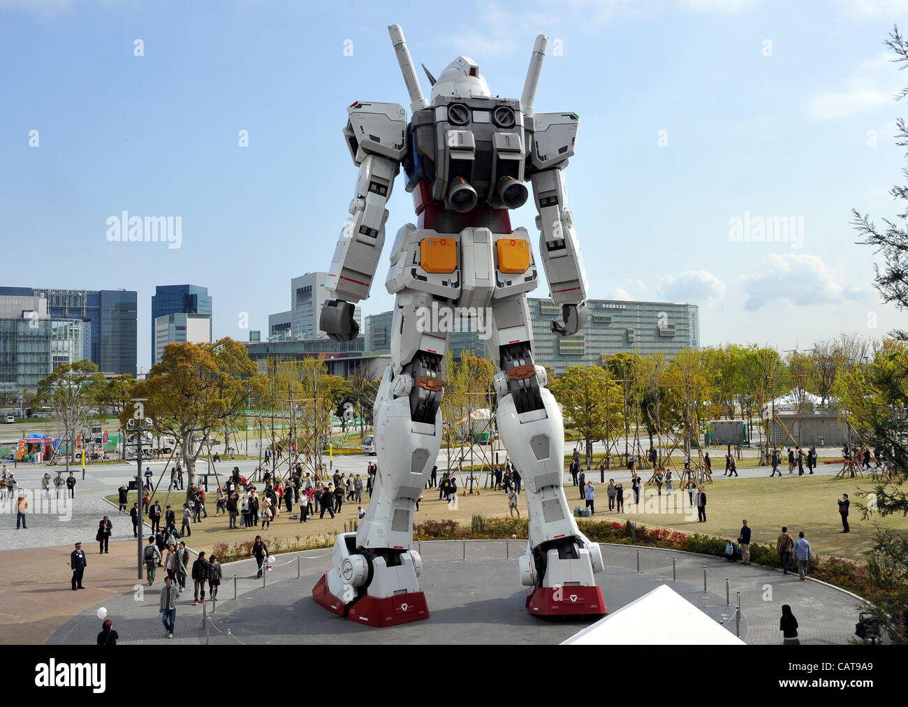 April 19, 2012, Tokyo, Japan. Spectators look up at 'Gundam' the 18-meter-tall  fighting robot from popular Japanese cartoon series returns to Odaiba,  Tokyos waterfront area to celebrate the grand opening of the