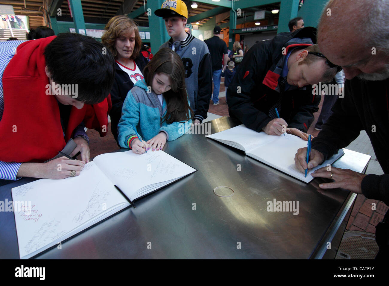 Boston, Massachusetts, USA. April 19, 2012. Red Sox Fans of all ages sign their names and birthday wishes to Fenway Park in blank books on its 100th Anniversary 'Open House'. Stock Photo