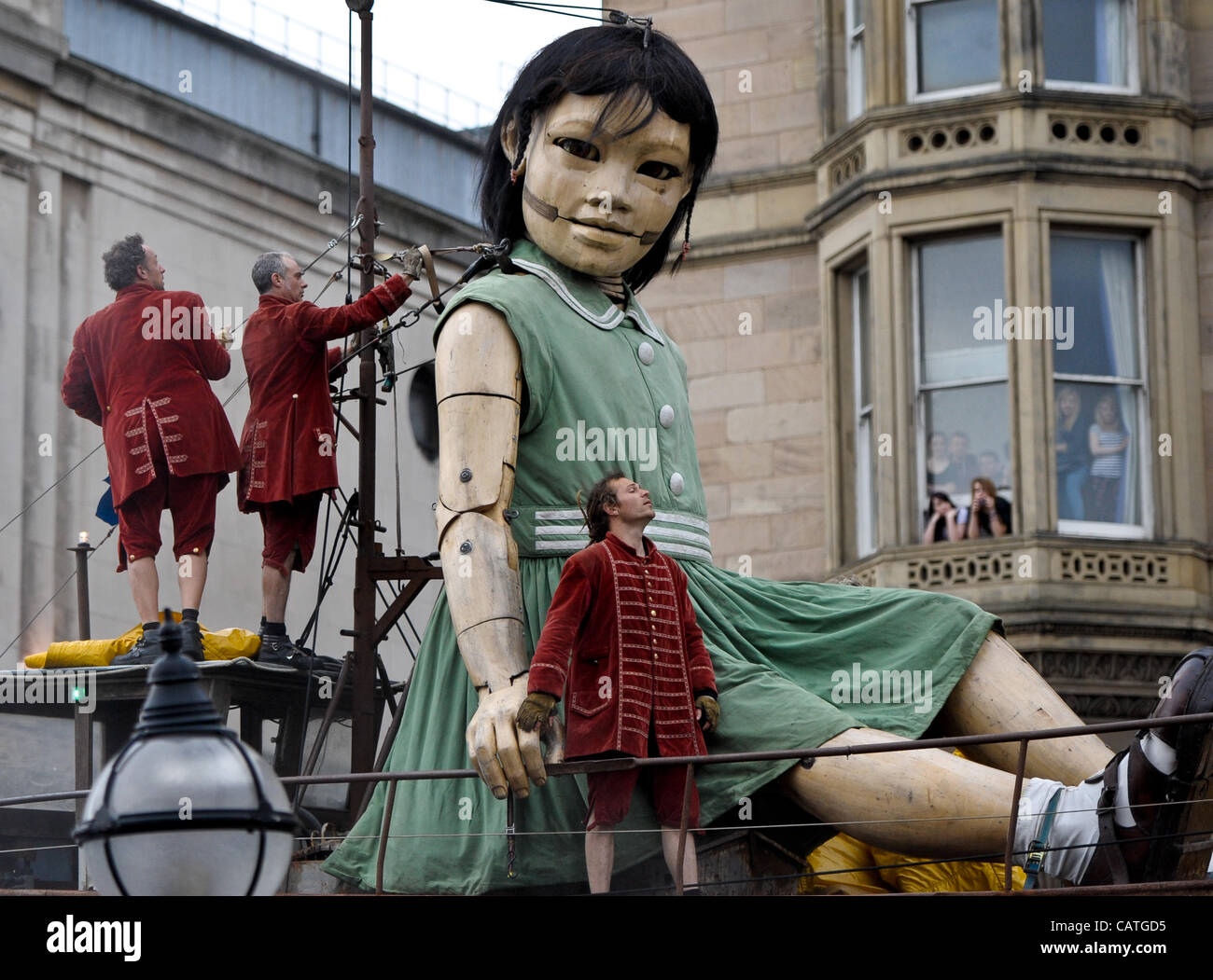 Liverpool, UK. 20 April, 2012. A giant puppet of a girl walks through