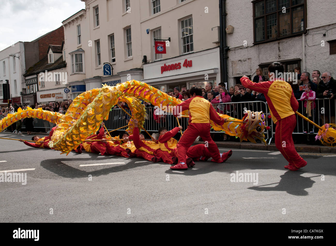 Bridge Street Stratford-upon-Avon UK 21/04/2012 Dancers from Fenghau High School China part of a cross cultural performance project bringing together the works of William Shakespear with those of Tang Xianzu who is regarded as the Shakespeare of the Orient performing a Chinese Dragon Dance during th Stock Photo