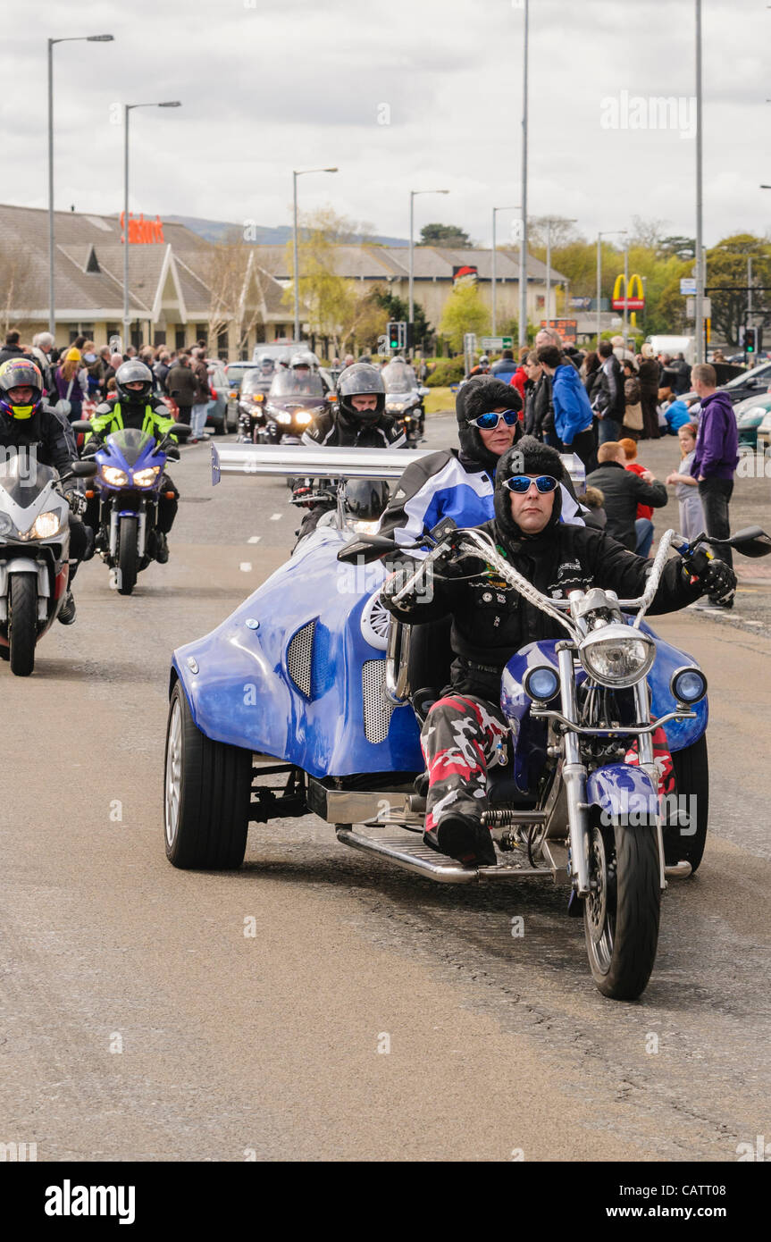 Biker rides a custom built tricycle on a road during a charity rideout