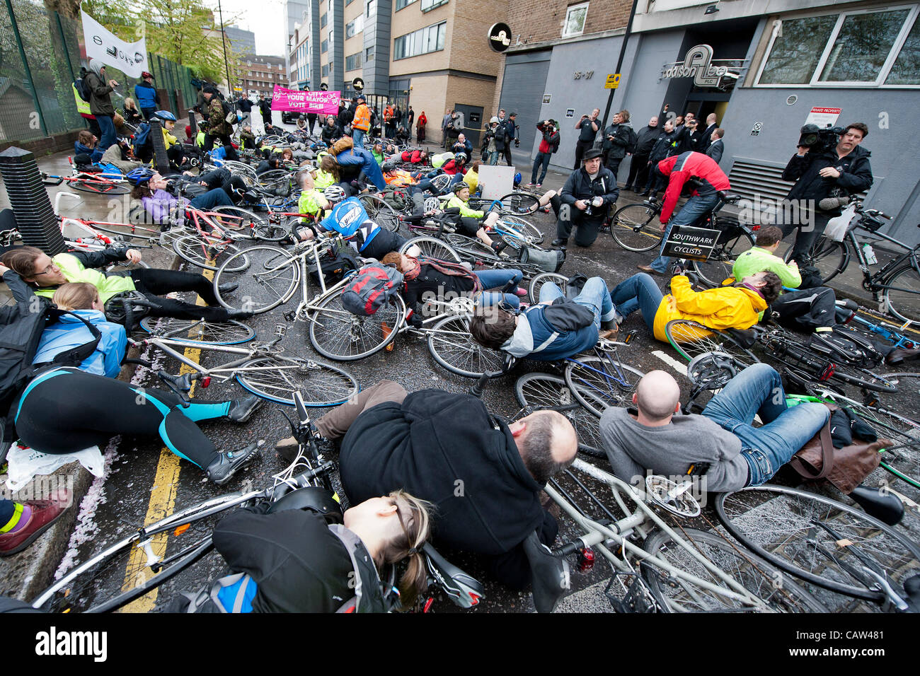 A mass 'die-in' outside of Addison Lee's London offices. They try to talk to John Griffin to highlight the danger his drivers pose to cyclists if they follow his instructions to use the bus lanes. He comes out but cannot be heard by the crowd.  Stanhope Street, London, UK 23rd April 2012. Stock Photo
