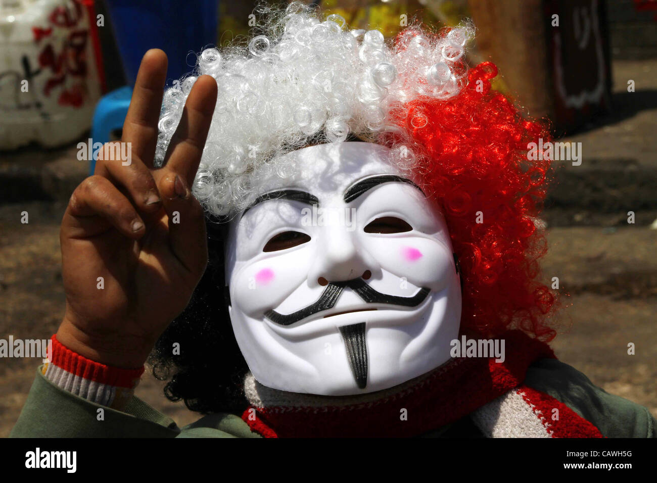 April 24, 2012 - Cairo,  Egypt - Egyptian man wearing anonymous mask and clown wig chants slogans during a protest at Tahrir Square. Several thousand Egyptians are protesting against the country's military rulers. (Credit Image: © Ashraf Amra/apaimages/ZUMAPRESS.com) Stock Photo