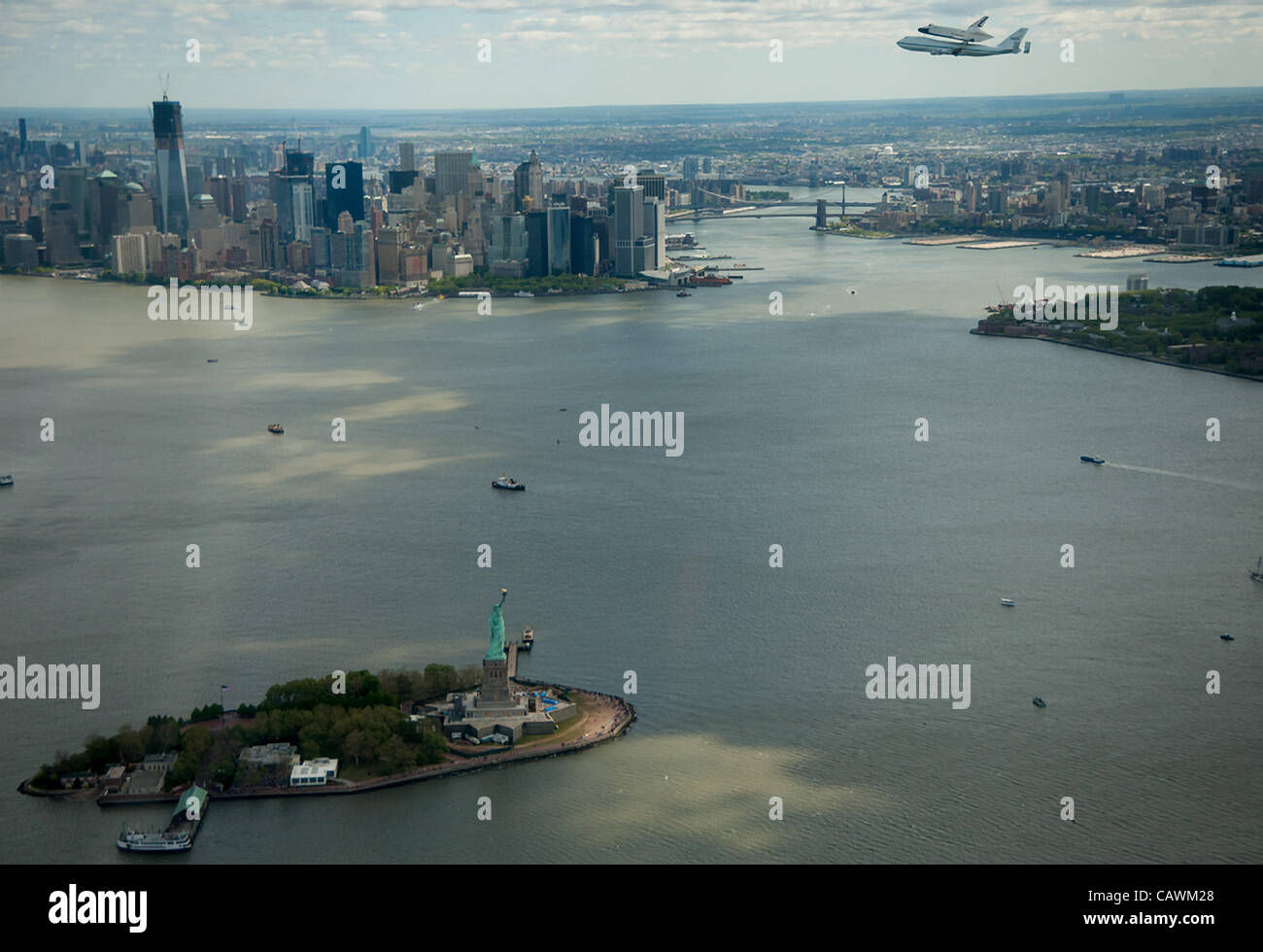 Space shuttle Enterprise, mounted atop a NASA 747 Shuttle Carrier Aircraft (SCA), is seen as it flies near the Statue of Liberty and the Manhattan skyline, Friday, April 27, 2012, in New York. Enterprise was the first shuttle orbiter built for NASA performing test flights in the atmosphere and was i Stock Photo