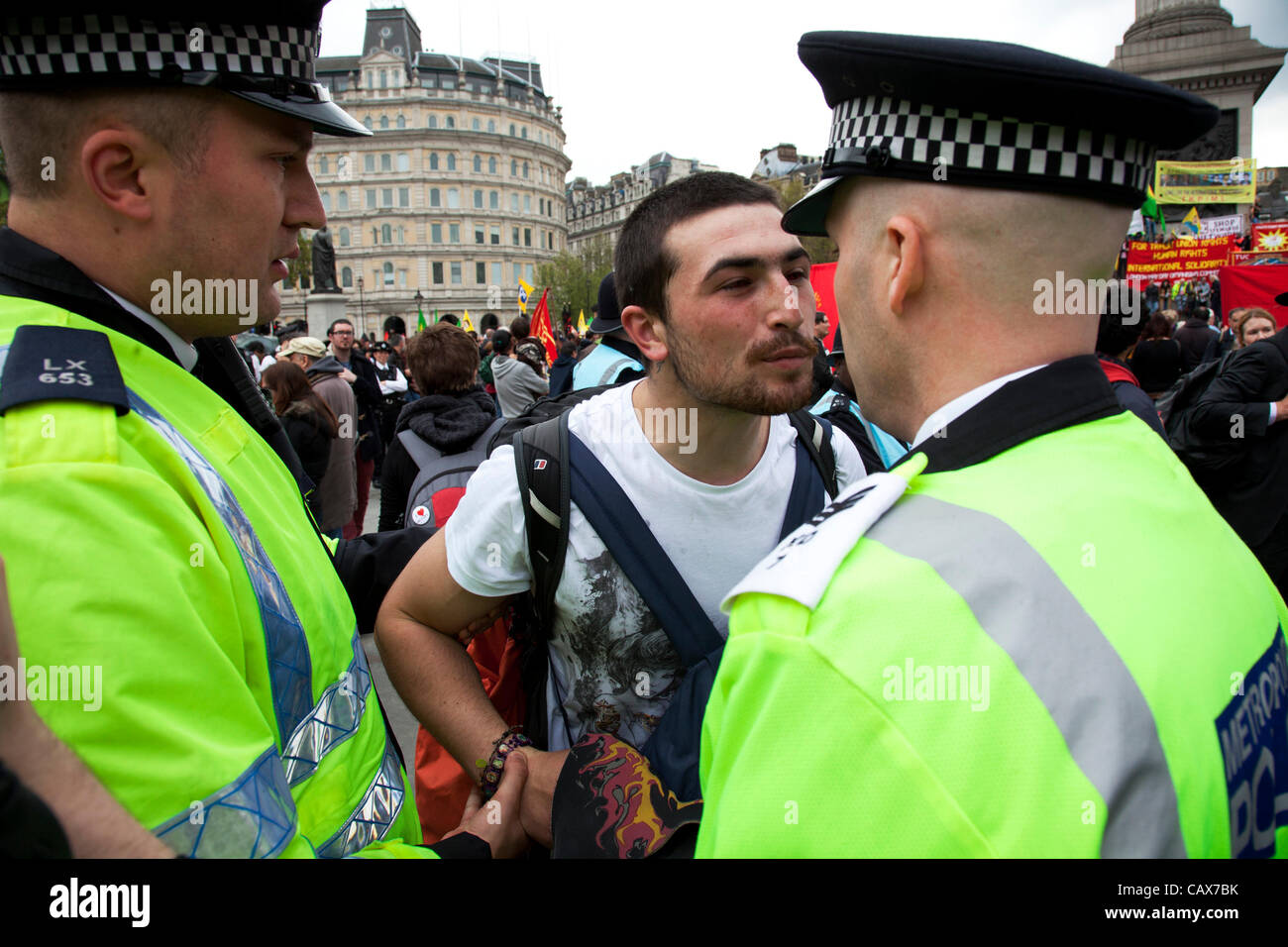 London, UK. 1 May, 2012. Police get into discussion with a protester they de-masked. Demonstration by unions and other organisations of workers to mark the annual May Day or Labour Day. Groups from all nationalities from around the World, living in London gathered to march. Stock Photo