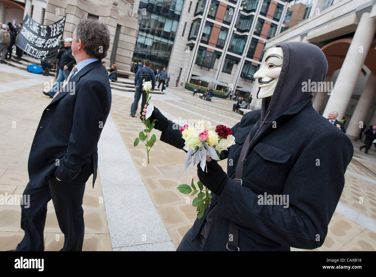 The May Day protest against government cuts to welfare, pensions and disability provision. Occupy London start at Paternoster Square, where they give out flowers, and move off to join the main union march. They set up tents at random and cause shops such as Top Shop to shut. London, UK, 1 May 2012. Stock Photo