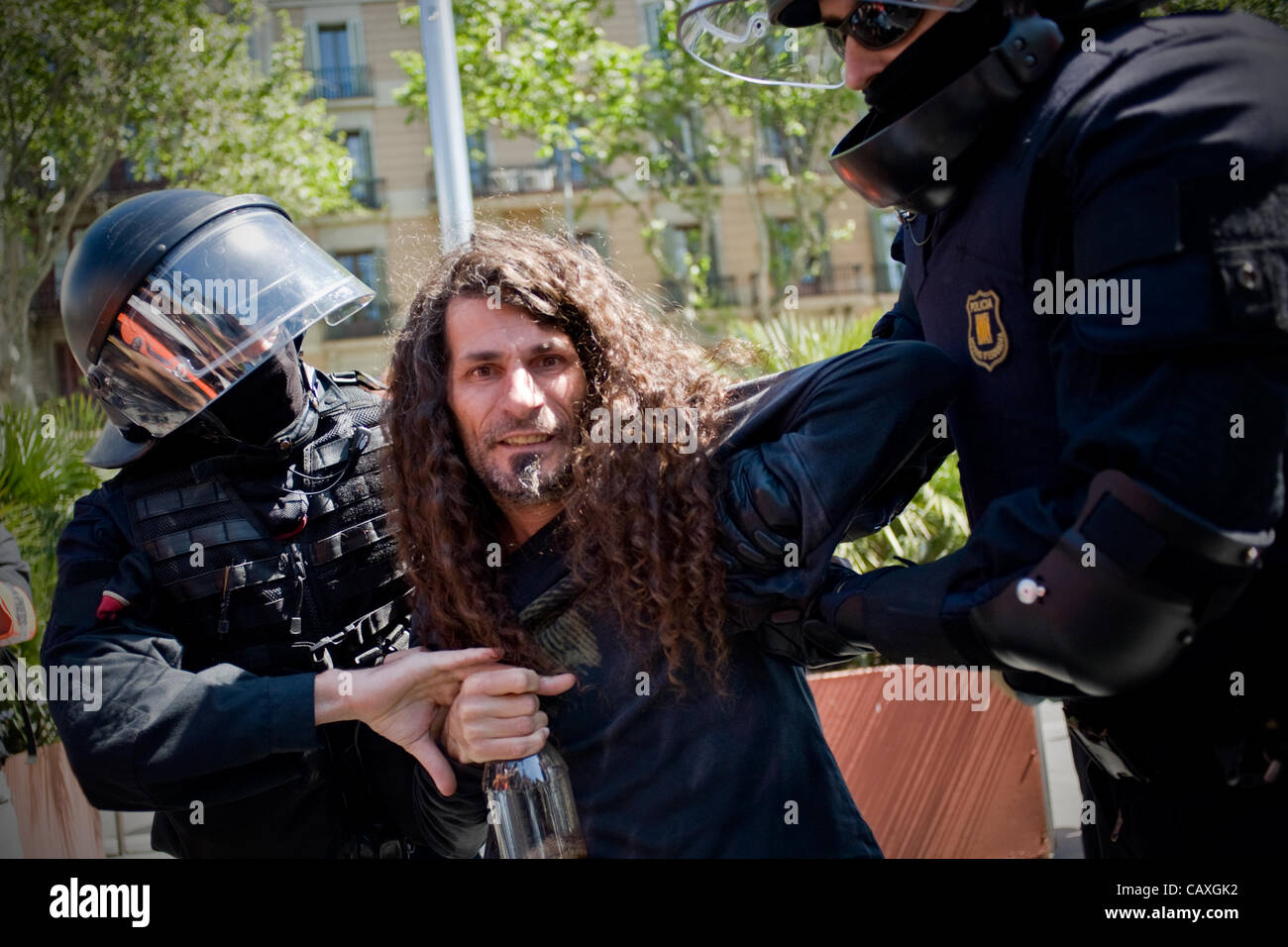 03 may, 20120-Barcelona, Spain. A man is detained by riot police during the march organized by students protesting cuts in public education. The march coincided with the visit of the European Central Bank in Barcelona which is why the city is strongly taken by the police . Stock Photo