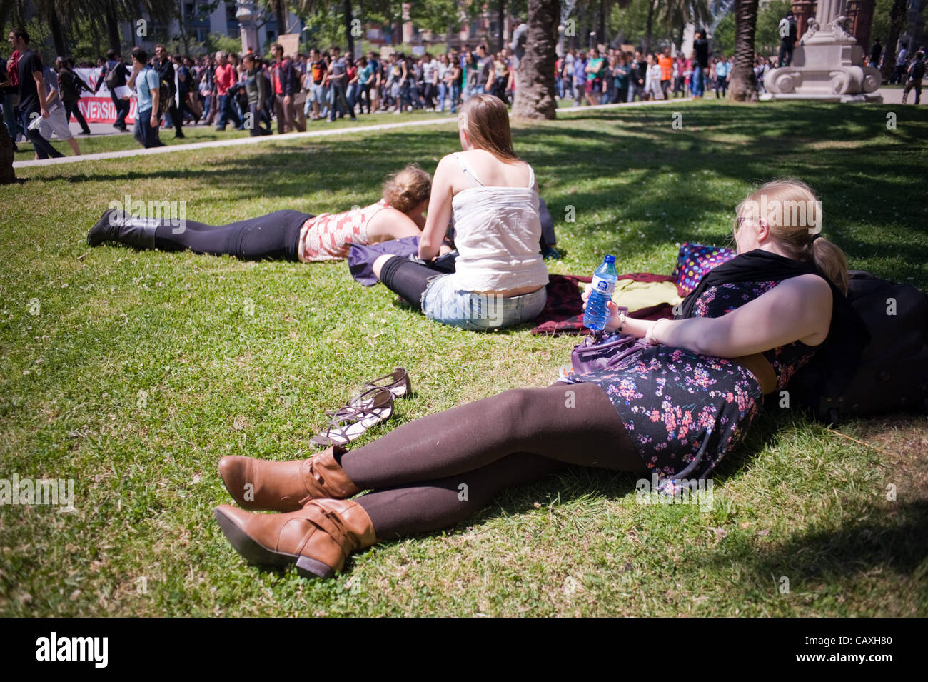 03 may, 2012-Barcelona, Spain. English tourist rest near the march organized by students protesting cuts in public education. The march coincided with the visit of the European Central Bank in Barcelona which is why the city is strongly taken by the police . Stock Photo