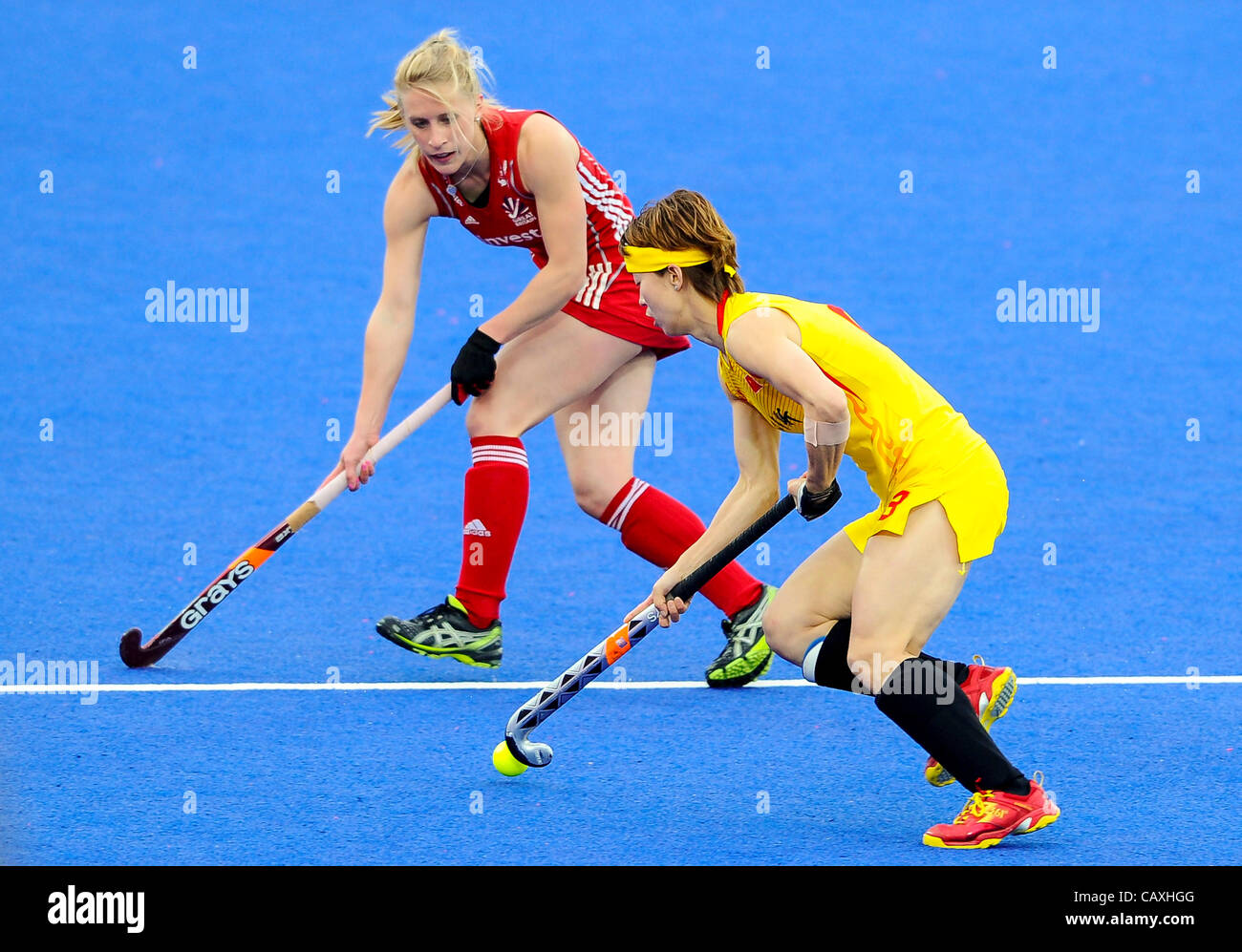 03.05.2012 London, England. China Forward # 8 Baorong FU (CHN) dribbles towards Great Britain Midfielder # 10 Susie GILBERT (GBR) during the Women’s Preliminary match between China and Great Britain on Day 2 of the Visa International Invitational Hockey Tournament at the Riverbank Arena on the Olymp Stock Photo