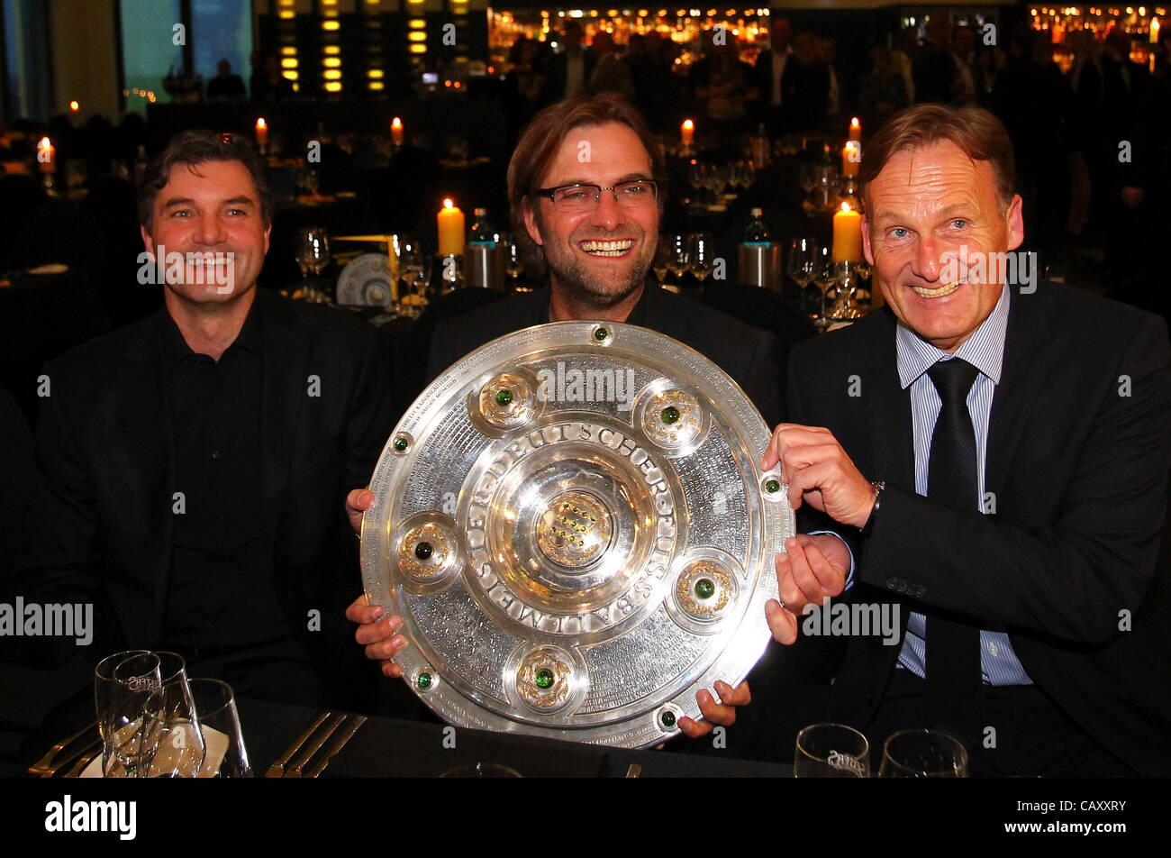 DORTMUND, GERMANY - MAY 05:  (L-R) Michael Zorc, manager of Dortmund, Juergen Klopp, head coach of Dortmund and managing director Hans Joachim Watzke pose with the trophy at View restaurant on May 5, 2012 in Dortmund, Germany *** Local Caption *** Michael Zorc; Juergen Klopp; Hans Joachim Watzke Stock Photo
