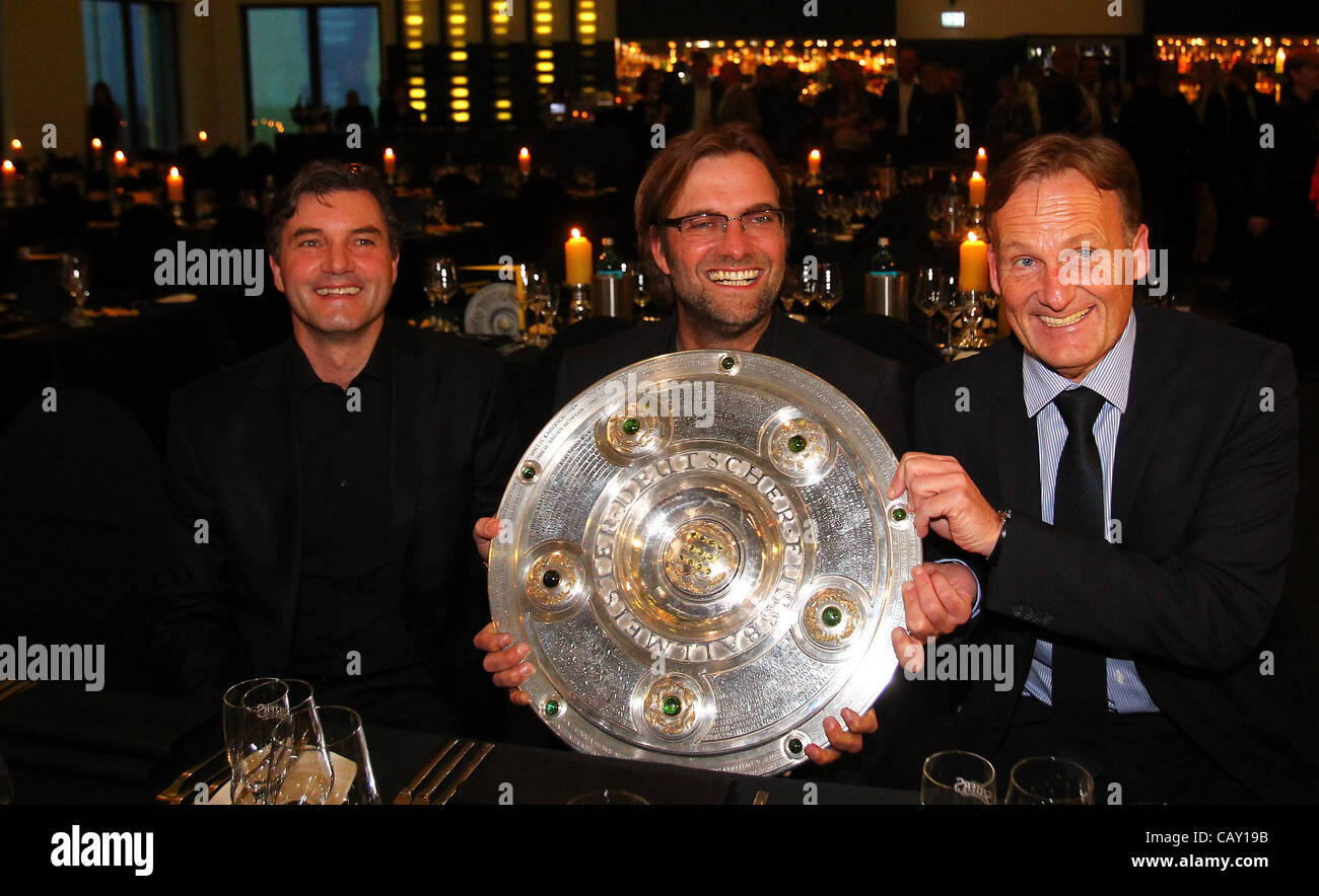 DORTMUND, GERMANY - MAY 05:  (L-R) Michael Zorc, manager of Dortmund, Juergen Klopp, head coach of Dortmund and managing director Hans Joachim Watzke pose with the trophy at View restaurant on May 5, 2012 in Dortmund, Germany. Stock Photo