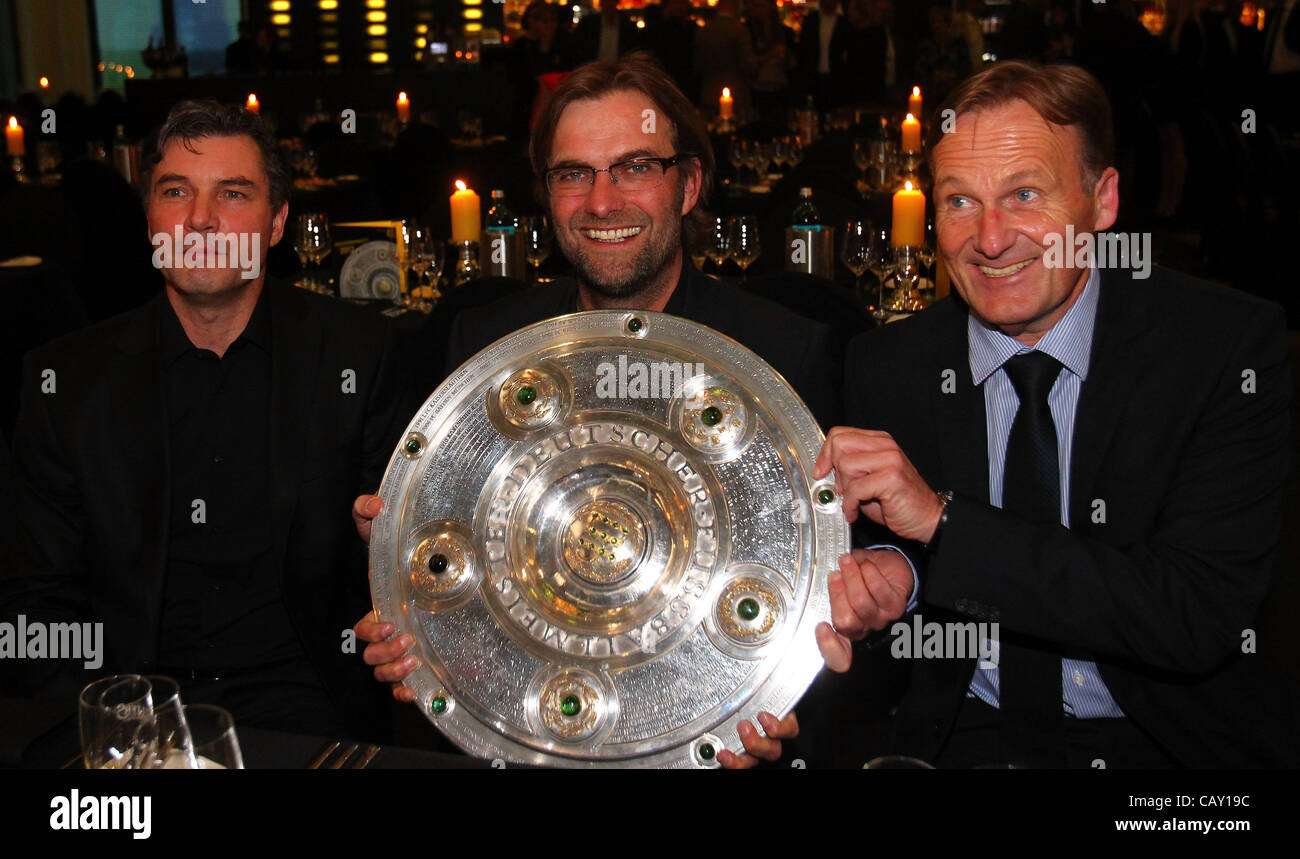 DORTMUND, GERMANY - MAY 05: (L-R) Michael Zorc, manager of Dortmund, Juergen Klopp, head coach of Dortmund and managing director Hans Joachim Watzke pose with the trophy at View restaurant on May 5, 2012 in Dortmund, Germany. Stock Photo