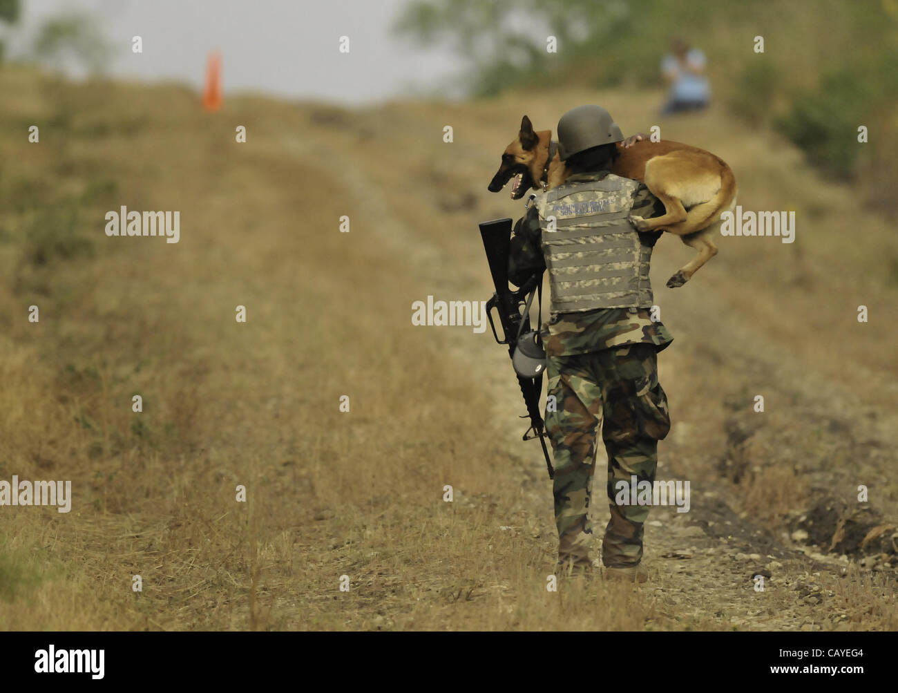 May 5, 2012 A soldier carries his K9 dog uphill as part of the Iron