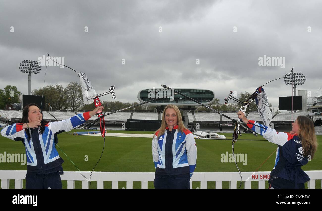 LORDS CRICKET GROUND, LONDON, UK, Wednesday. 09/05/2012. (L to R) Amy Oliver, Alison Williamson and Naomi Folkard with bows drawn and the Lords media centre in the background. 6 Archers announced for Team GB. Stock Photo
