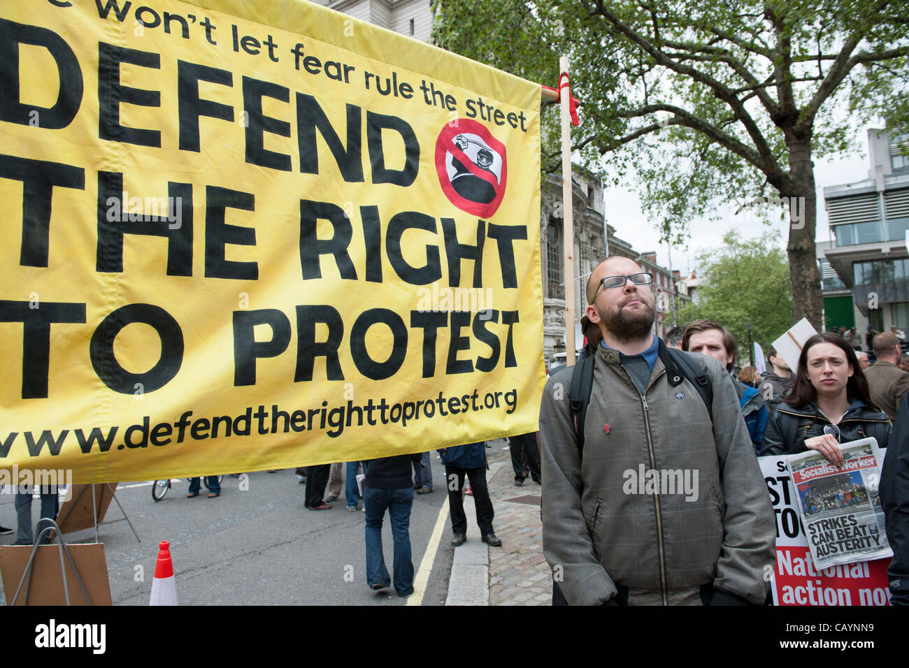 Banner proclaiming the right to protest being held in central London with activists selling Socialist Worker newspaper. Stock Photo
