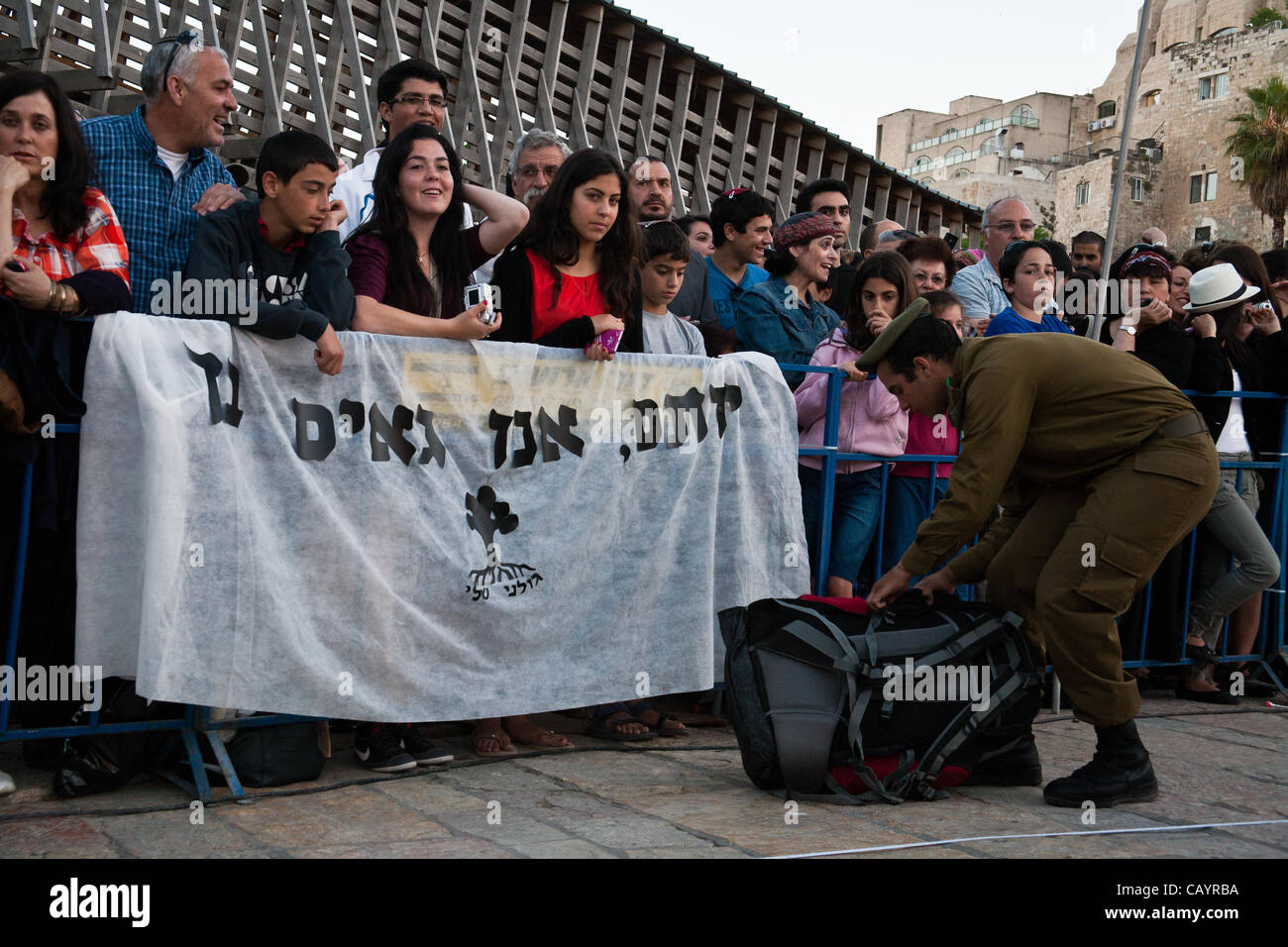 One family, awaiting the Golani Brigade Oath of Allegiance ceremony, hang a Hebrew banner reading “Yotam, we are proud of you” at the Western Wall. Jerusalem, Israel. 10-May-2012. Stock Photo