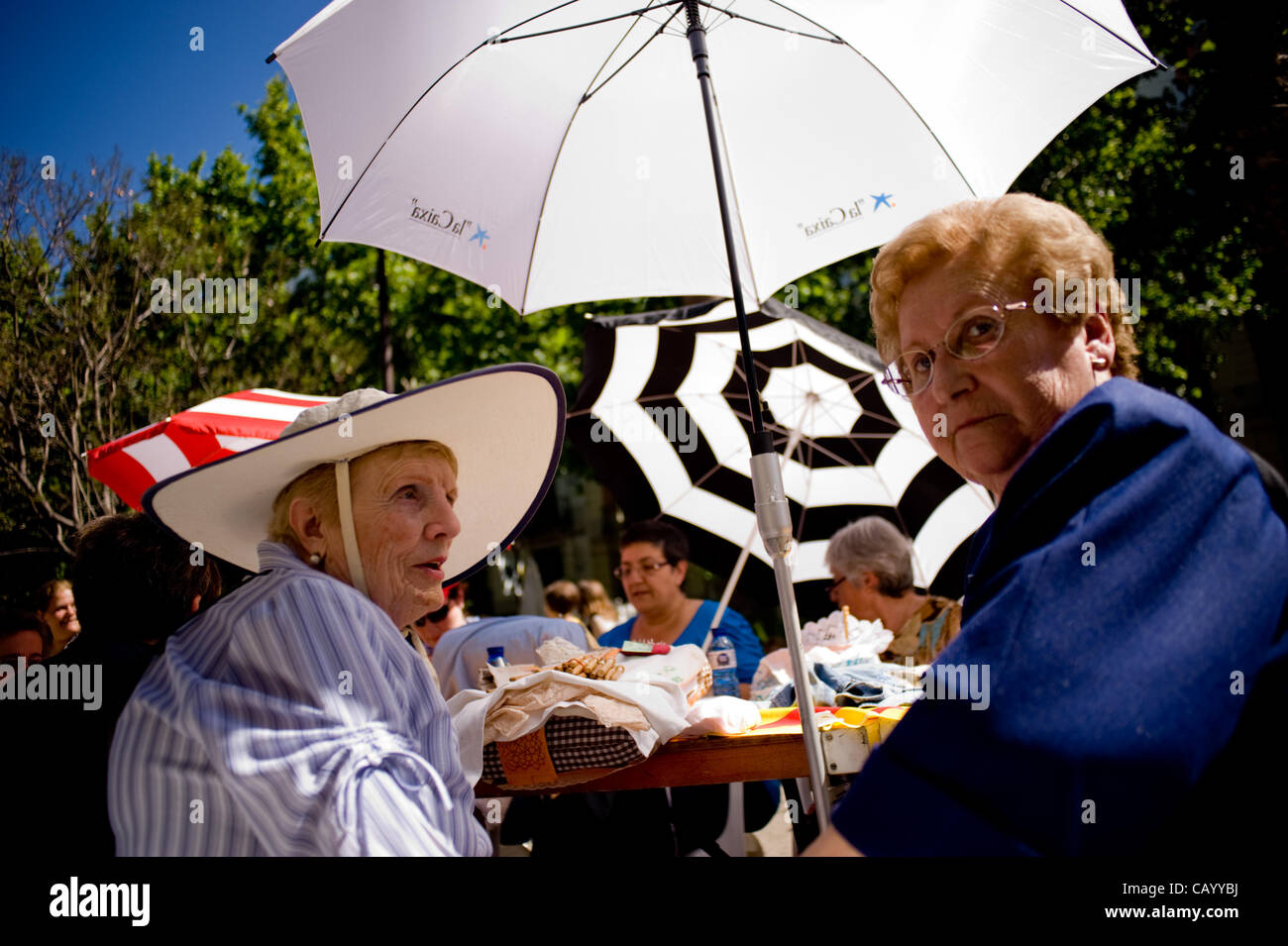 11 May, 2012-Barcelona, Spain. Women cover the hot sun with hats and umbrellas during the 11th Meeting of lace makers in Barcelona. 350 lace makers have gathered in the Rambla del Raval as part of the celebrations that are held by the festival of Sant Ponç (St. Pontius) (Credit Image: Jordi Boixareu Stock Photo