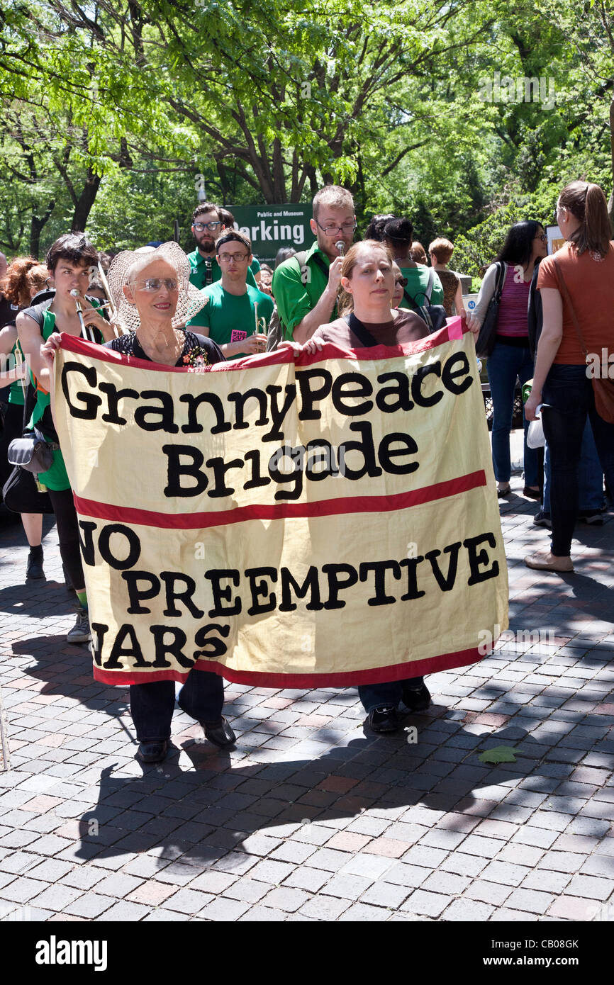 two women holding banner lead musicians & marchers along Fifth Avenue sidewalk on the Granny Peace Brigade sixth annual Mother's day Peace Stroll on a beautiful Mother's Day afternoon in New York City Stock Photo