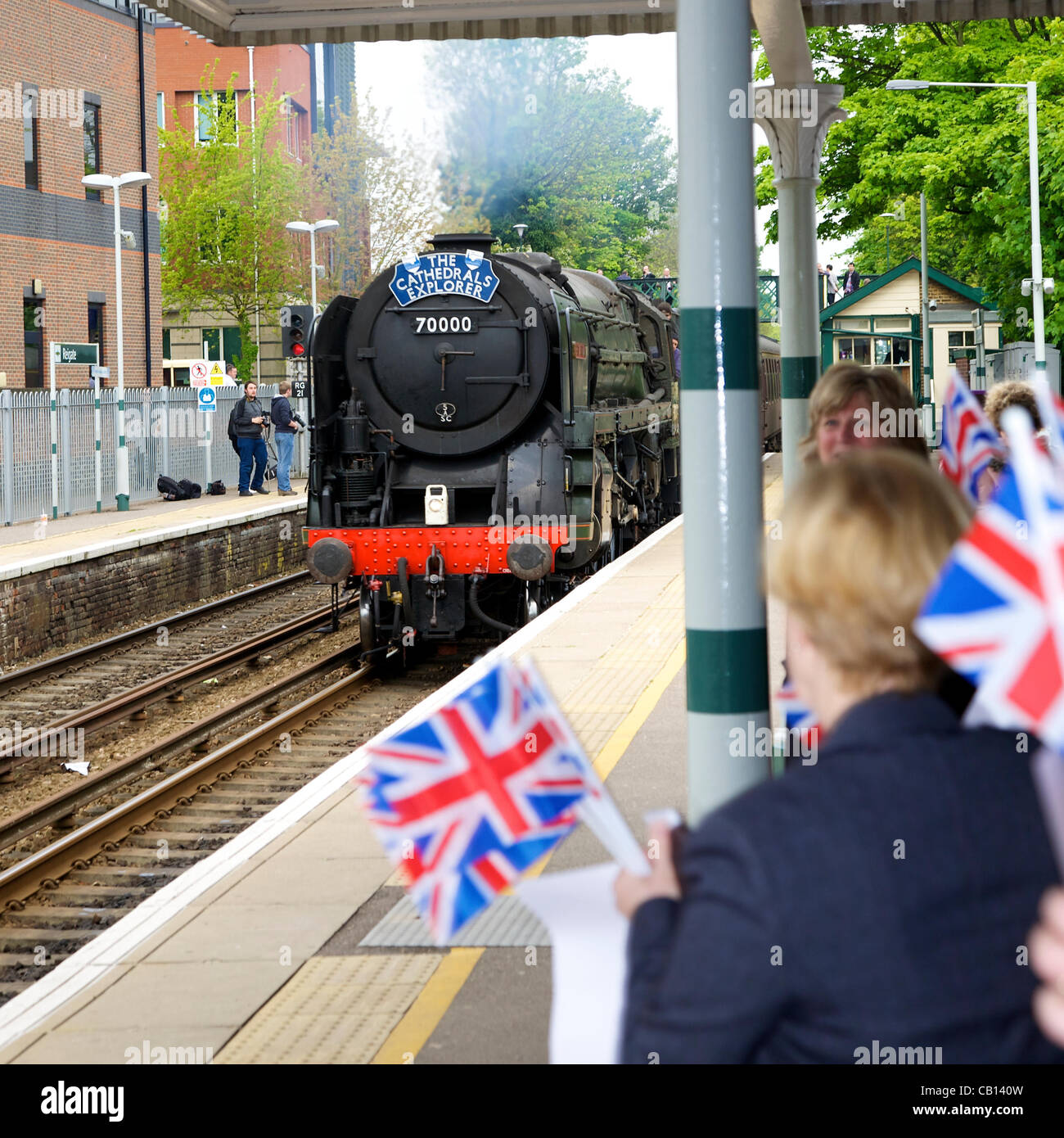 Welcomed by excited flag waving crowds as it passed Reigate Station in Surrey at 0903hrs Friday 18th May 2012 is 'Cathedrals Explorer' Britannia Class 7MT 4-6-2 no 70000 Britannia steam locomotive en route to Durham on an 8 day tour. With 67026 DB Schenker Class Diesel 'Diamond Jubilee' at the rear Stock Photo