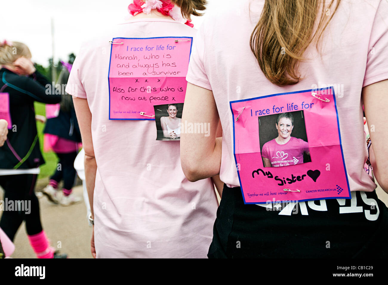'I race for life for' cards on the backs of two participants at the Cancer Research Race for Life in Norwich Showground, Norwich, Norfolk, UK on 19 May 2012 Stock Photo