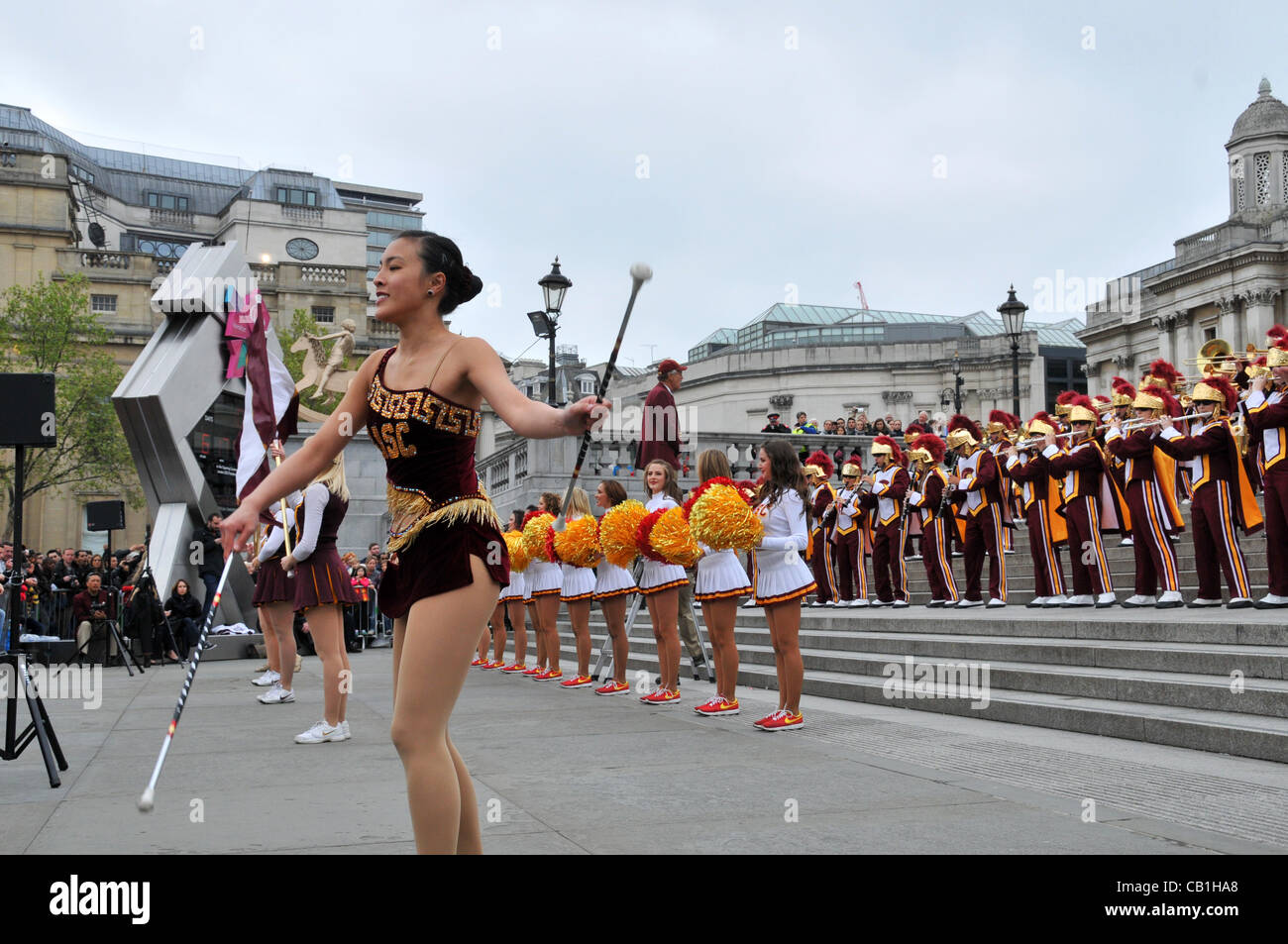 London, UK. 20/05/2012. A baton twirler and cheerleaders of the University of Southern California (USC), Trojans Football Team Marching Band perform in front of the Olympic Clock in Trafalgar Square, London, UK. Stock Photo