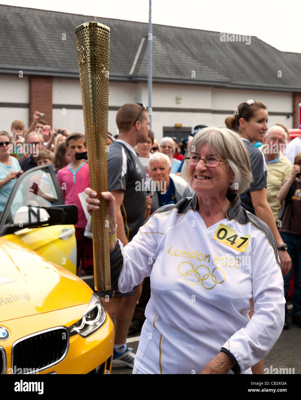 Dorothy Turner of Caldicot aged 70 carrying the flame during the torch relay for the London 2012 Olympics through Abergavenny, Wales, UK on Friday 25 May 2012 Stock Photo