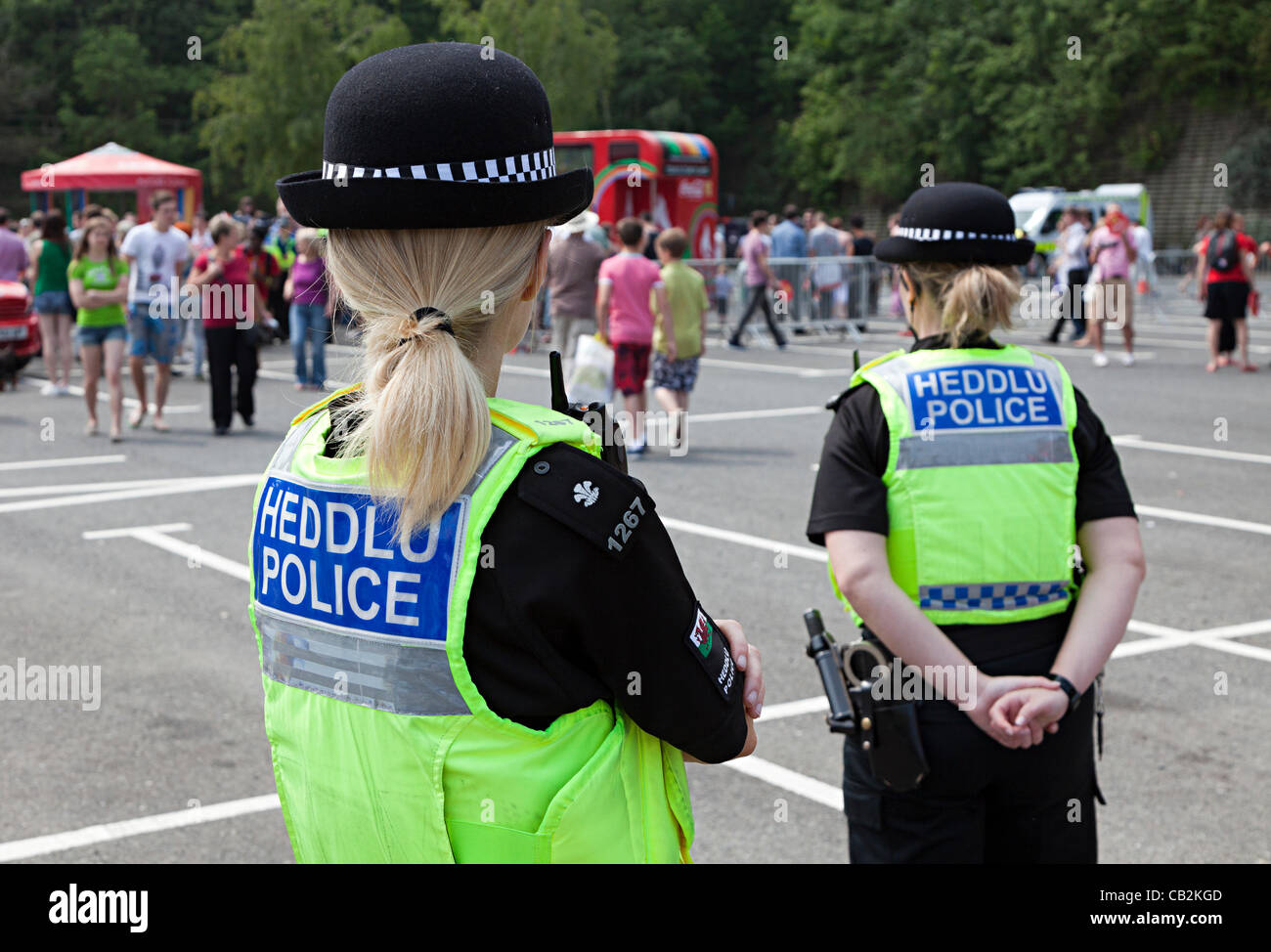 Female police watching people at an event in Abergavenny, Wales, UK Stock Photo