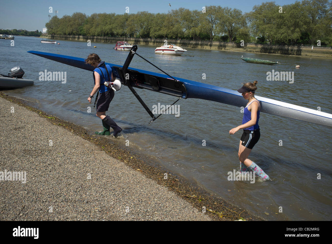 Putney Riverside Rowing 25 May, 2012. Putney London, UK. Two Female rowers carry a rowing boat ...