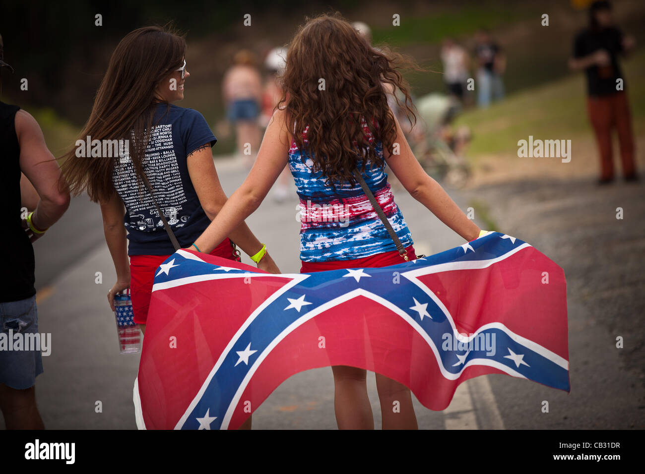 Two young women with a confederate flag at the Summer Redneck Games on May 26, 2012 in East Dublin, Georgia. The games honor the southern red neck culture. Stock Photo