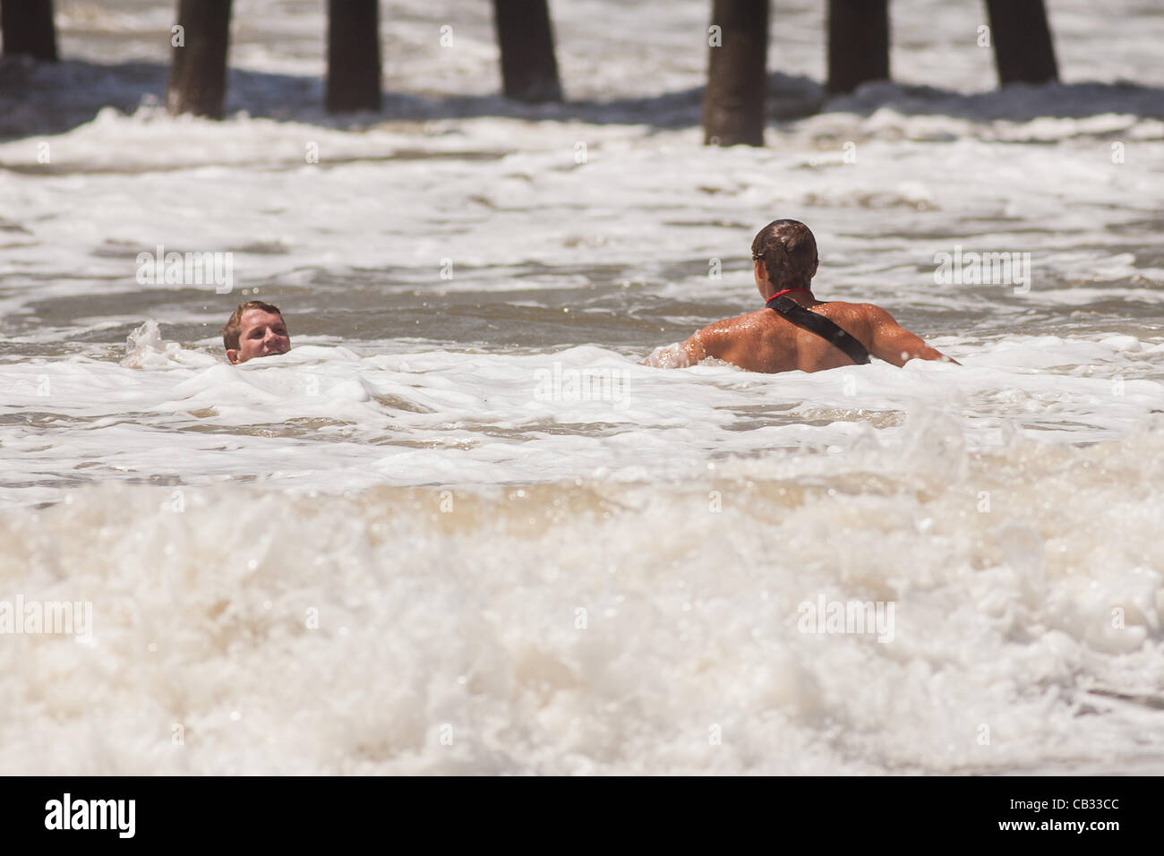 USA. A Charleston County life guard rushes to assist a swimmer caught in a rip tide as Tropical Storm Beryl brushes past the South Carolina coast on May 27, 2012 in Folly Beach, South Carolina.  The storm caused local beaches to restrict swimming due to strong currents and and rip tides Stock Photo
