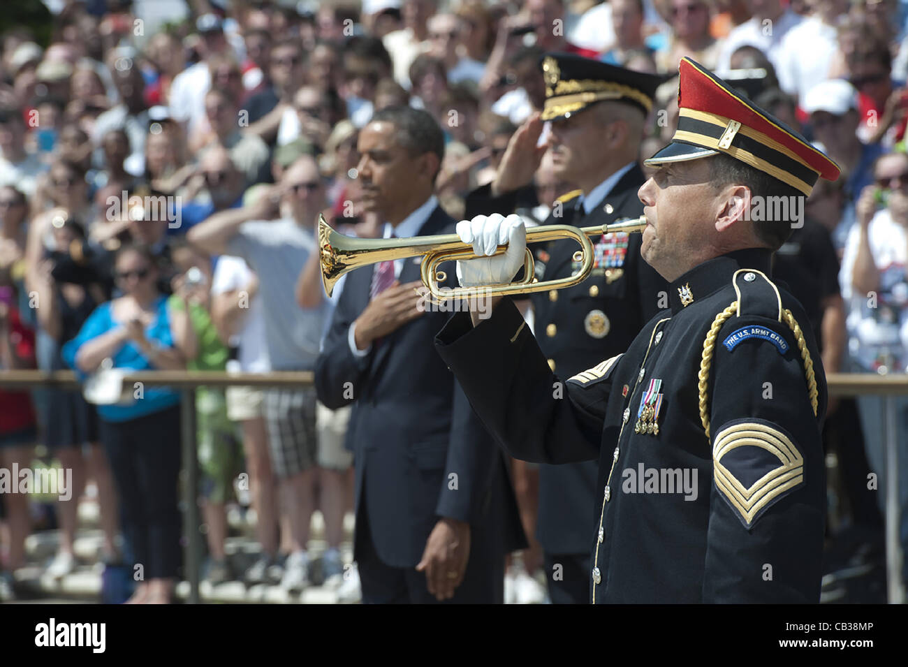 US President Barack Obama stands for a moment of silence as an Army bugler plays taps during Memorial Day services at Arlington National Cemetery May 28, 2012 in Arlington, VA Stock Photo