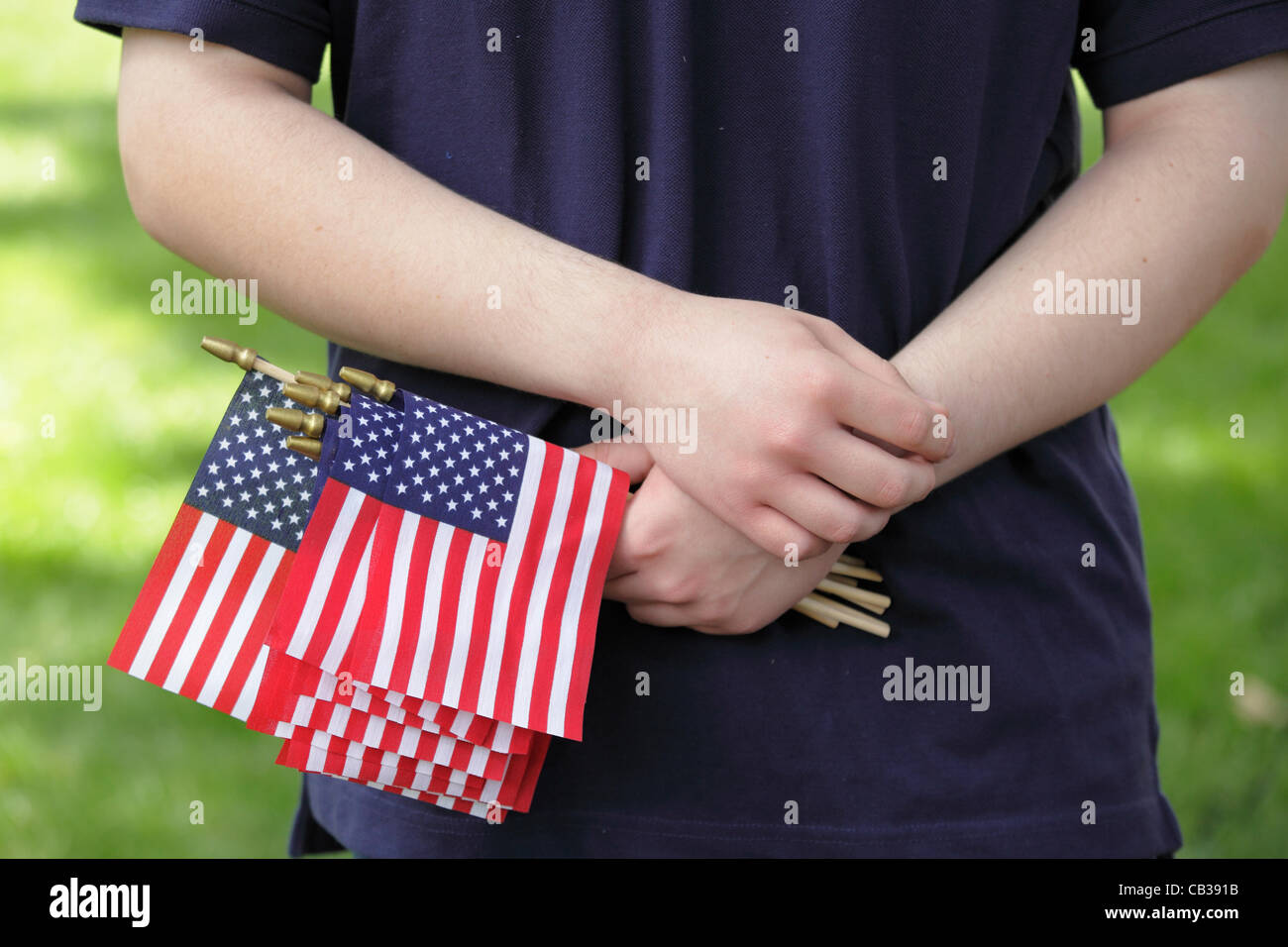 An adolescent male holds miniature American flags in his hand at a Memorial Day ceremony in Raleigh, North Carolina, USA, May 28, 2012. Stock Photo