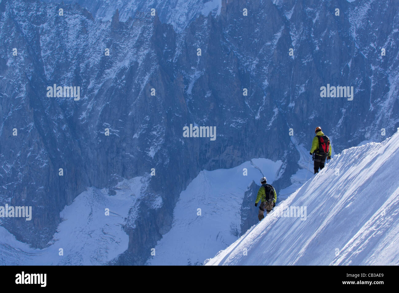 Two mountaineers descend from the Aigulle du Midi into the Col du Plan in the Mt Blanc range Stock Photo