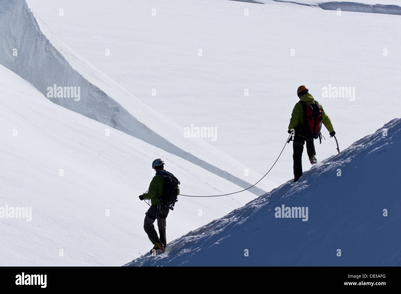 Two mountaineers descend from the Aigulle du Midi into the Col du Plan in the Mt Blanc range Stock Photo
