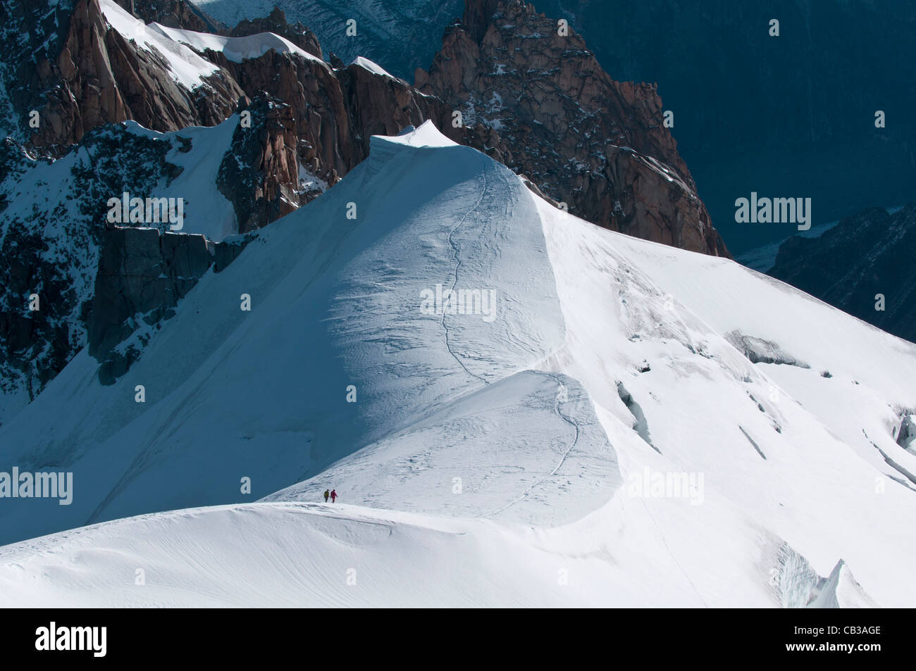 Two mountaineers descend from the Aigulle du Midi into the Col du Plan in the Mt Blanc range Stock Photo