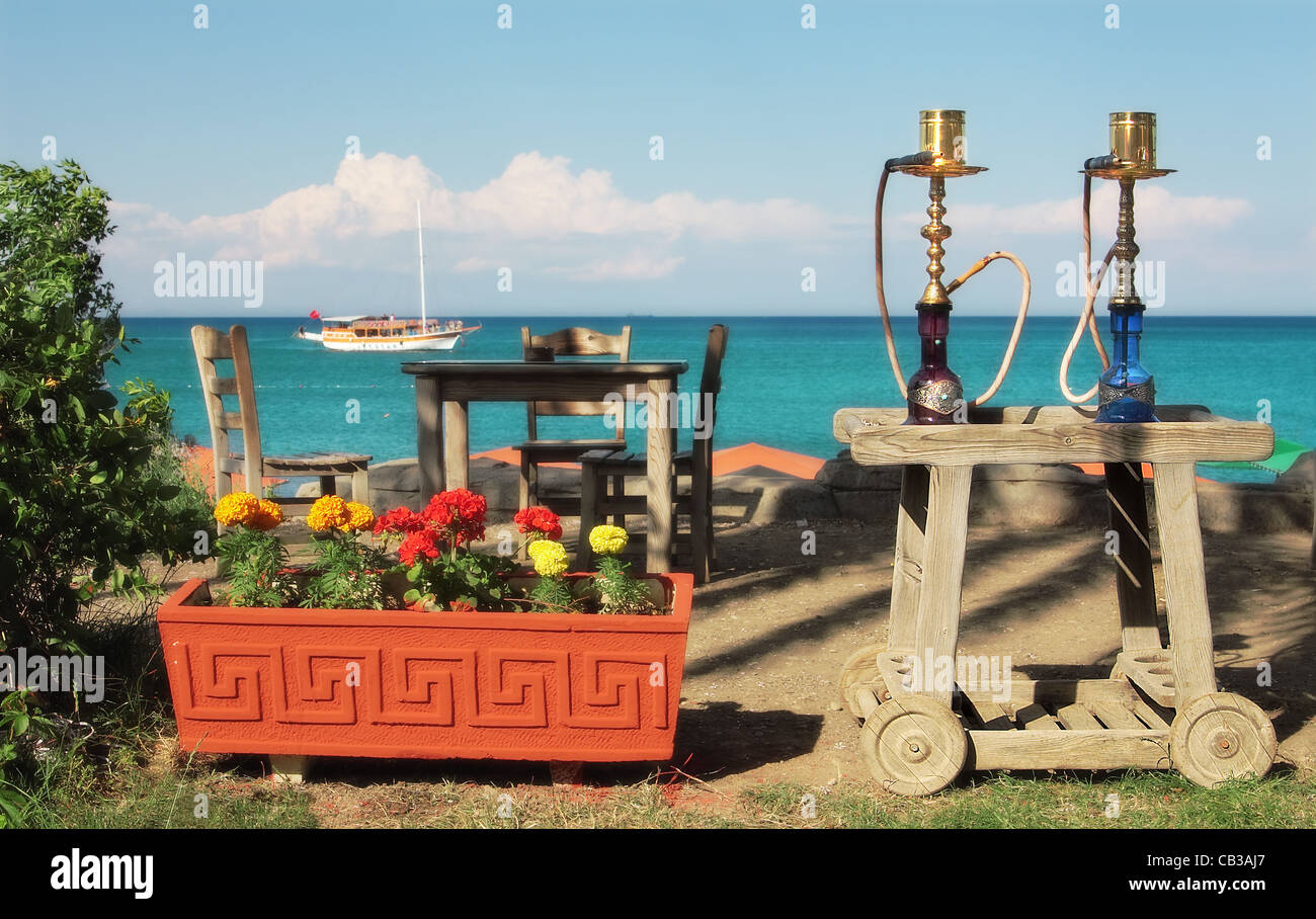 Two traditional turkish waterpipes (nargile) on the table in outdoor restaurant with view on Mediterranean sea in Kemer, Turkey. Stock Photo