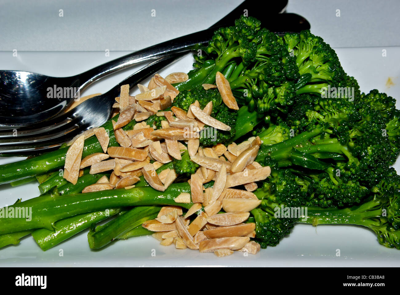 Steamed broccolini vegetable side dish with toasted slivered almonds Stock Photo
