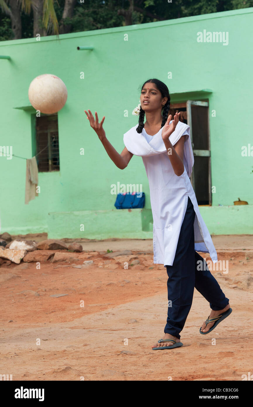 Young Indian school girl throwing a ball in a rural indian village. Andhra Pradesh, India Stock Photo