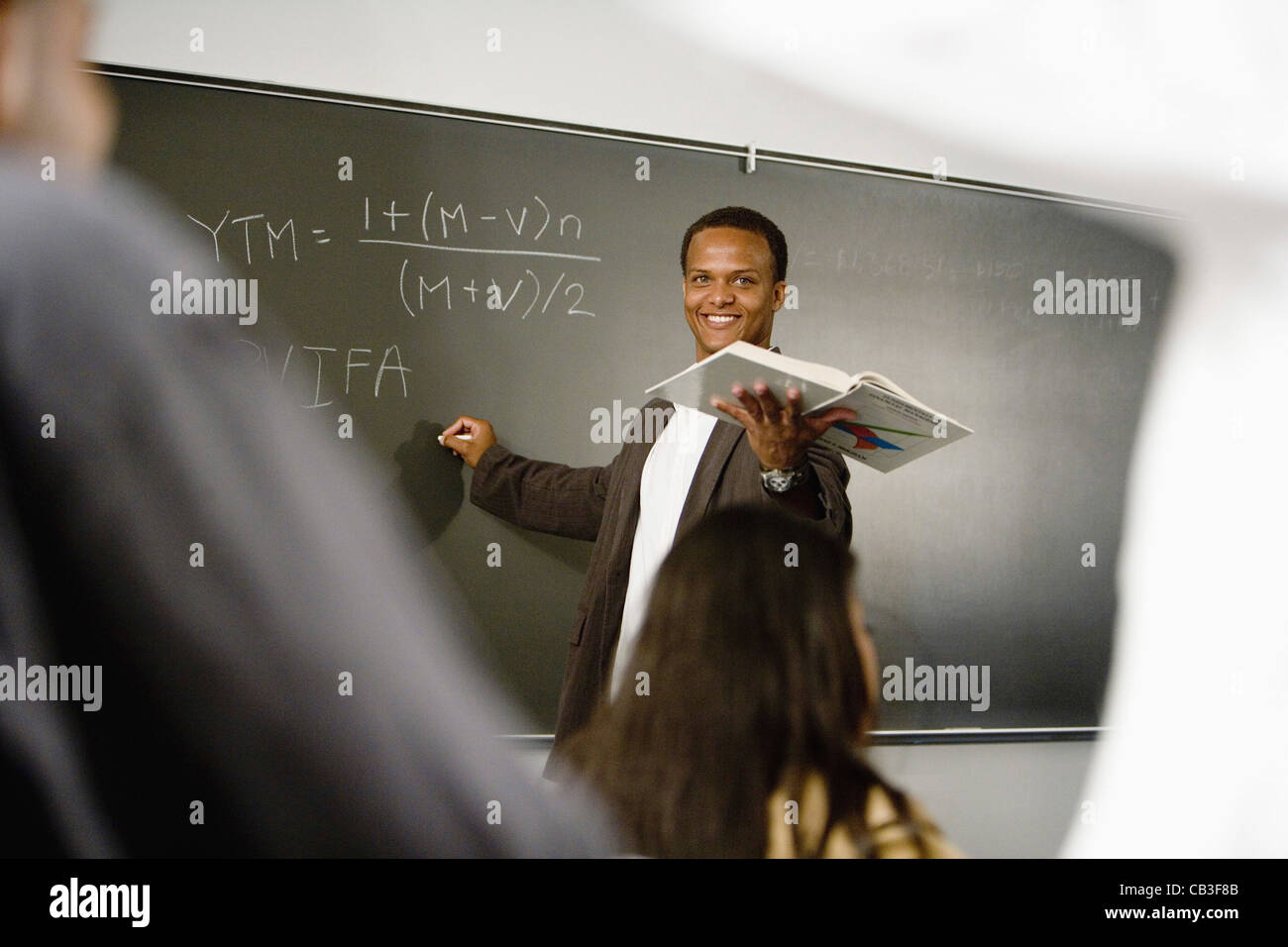 Teacher teaching students in the classroom Stock Photo - Alamy