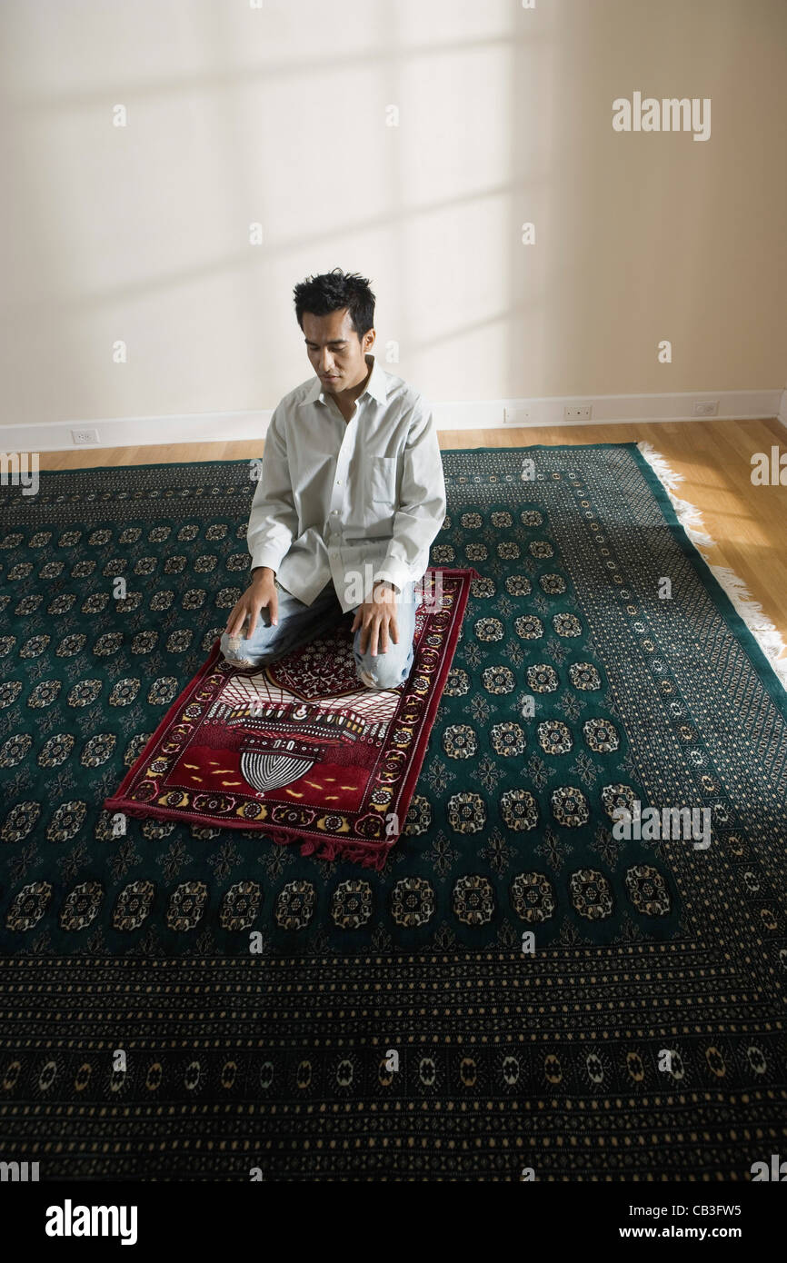 A Muslim man praying on a prayer mat Stock Photo Alamy