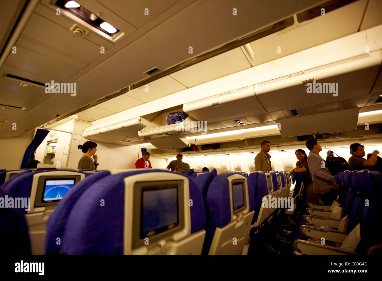 passengers boarding a 747 passenger aircraft with open overhead lockers Stock Photo
