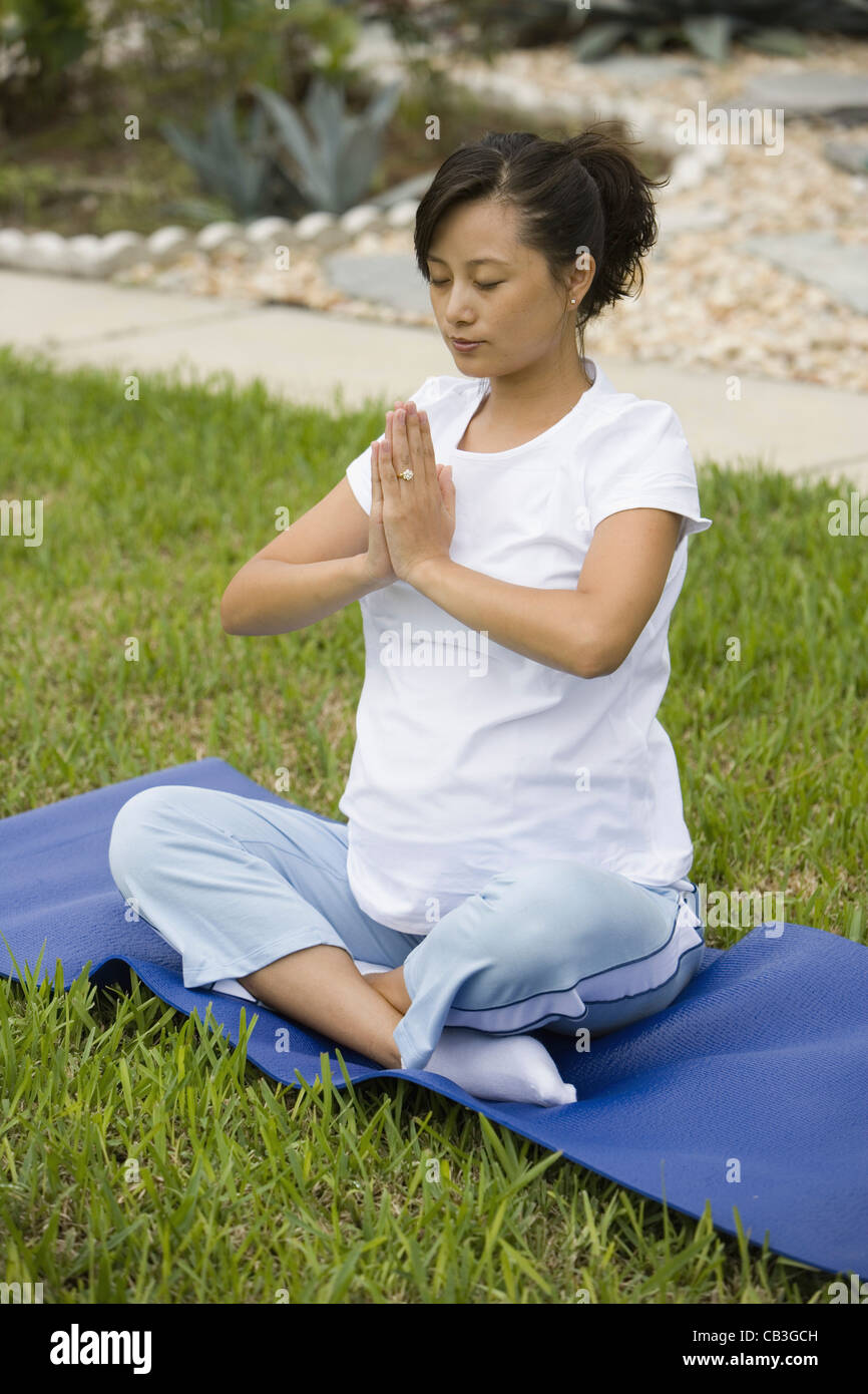 Pregnant woman in yoga position on lawn Stock Photo - Alamy