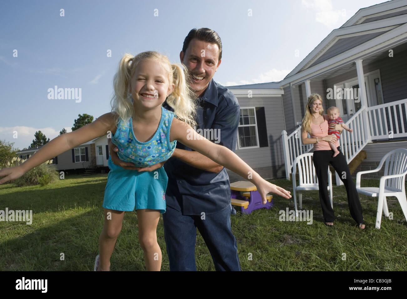 Portrait of a man playing with his bluecollar family in front of a