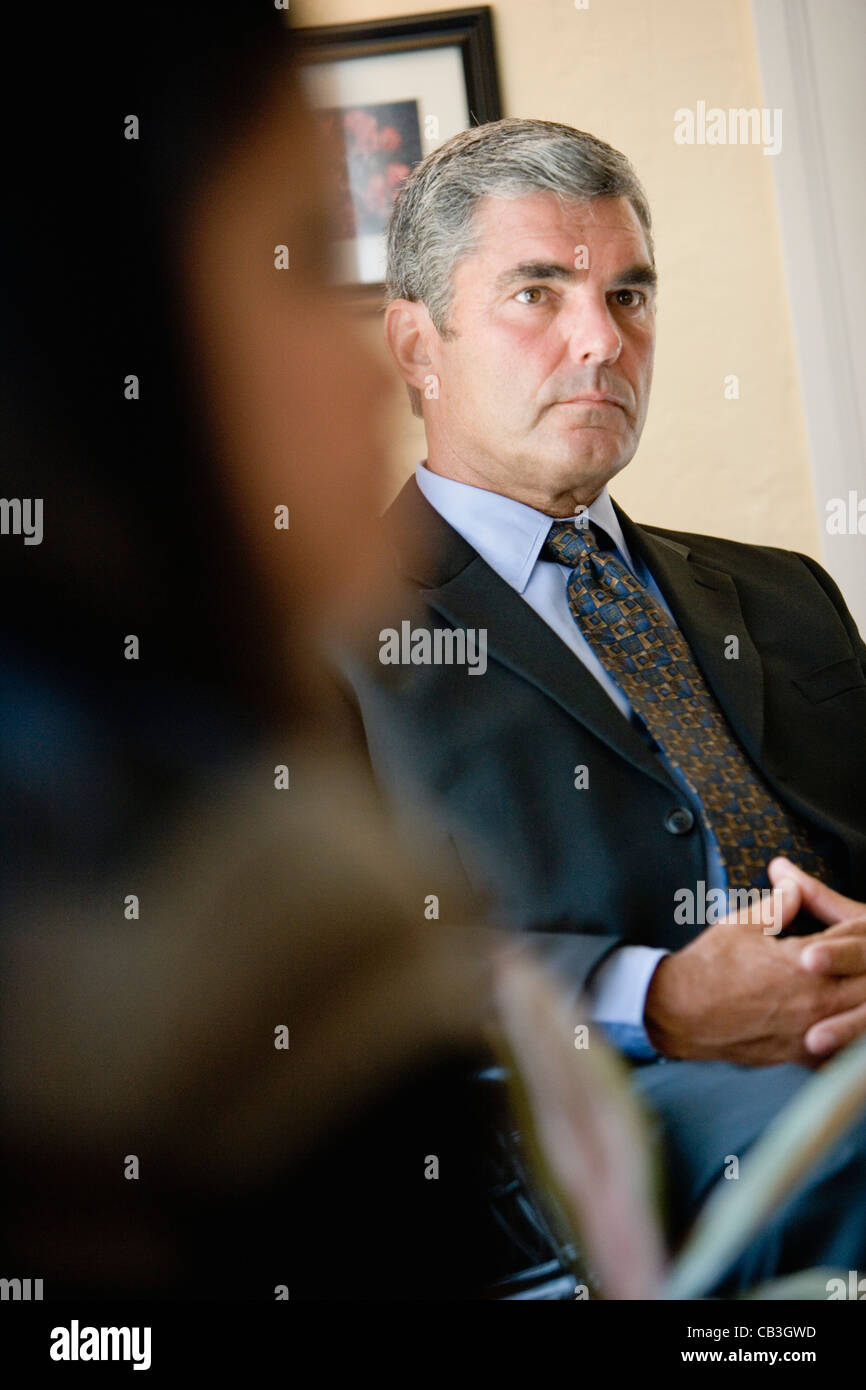 Businessman and woman sitting in office Stock Photo - Alamy