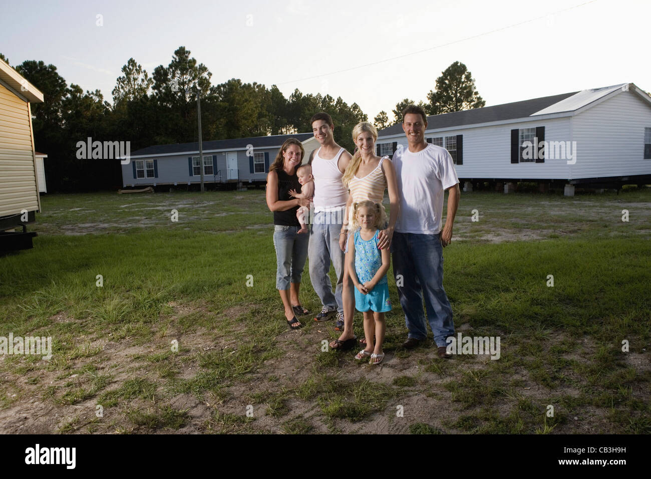Portrait of two bluecollar families standing in front of trailer homes Stock Photo Alamy