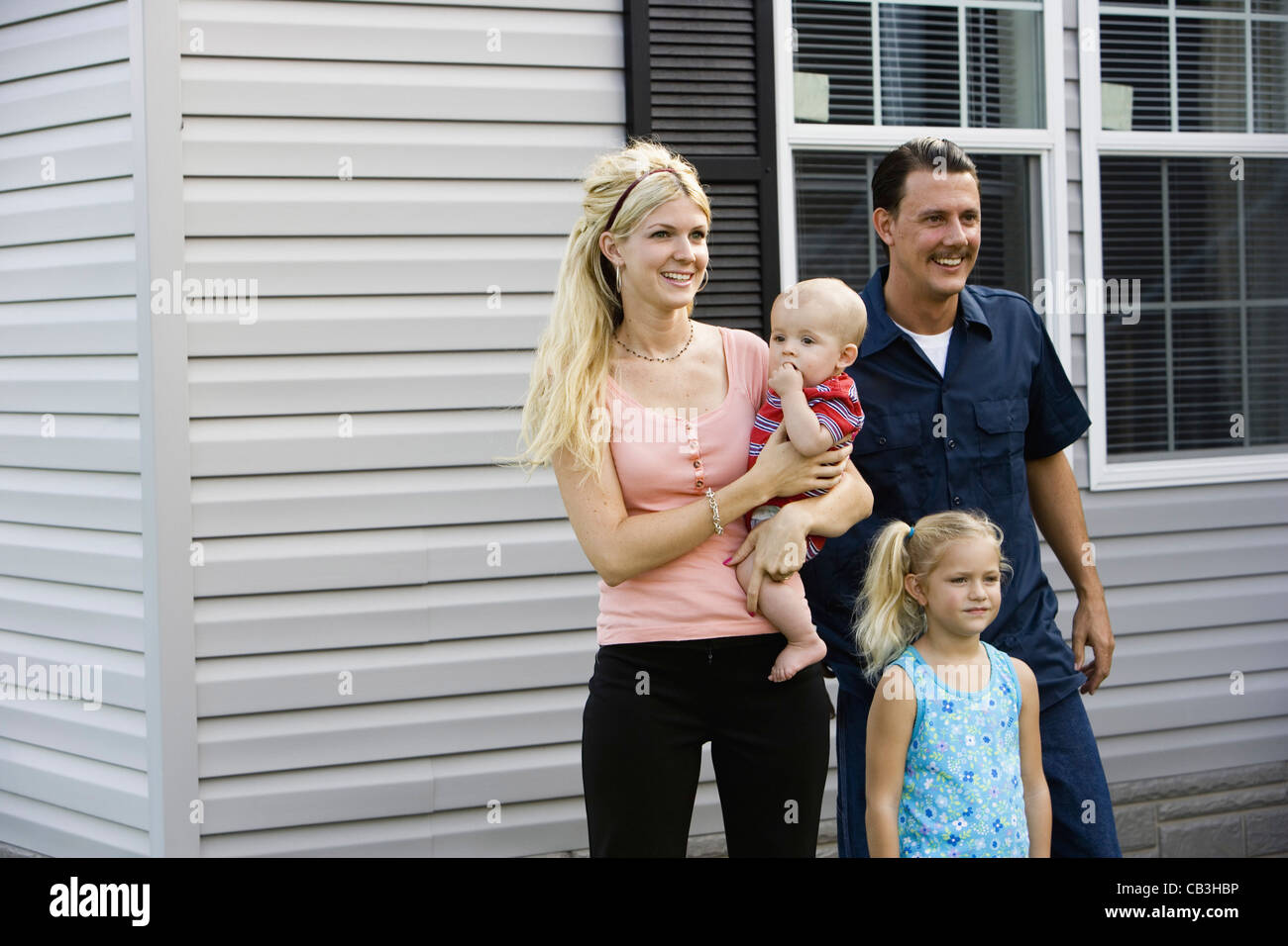 A family standing together outside their home Stock Photo - Alamy